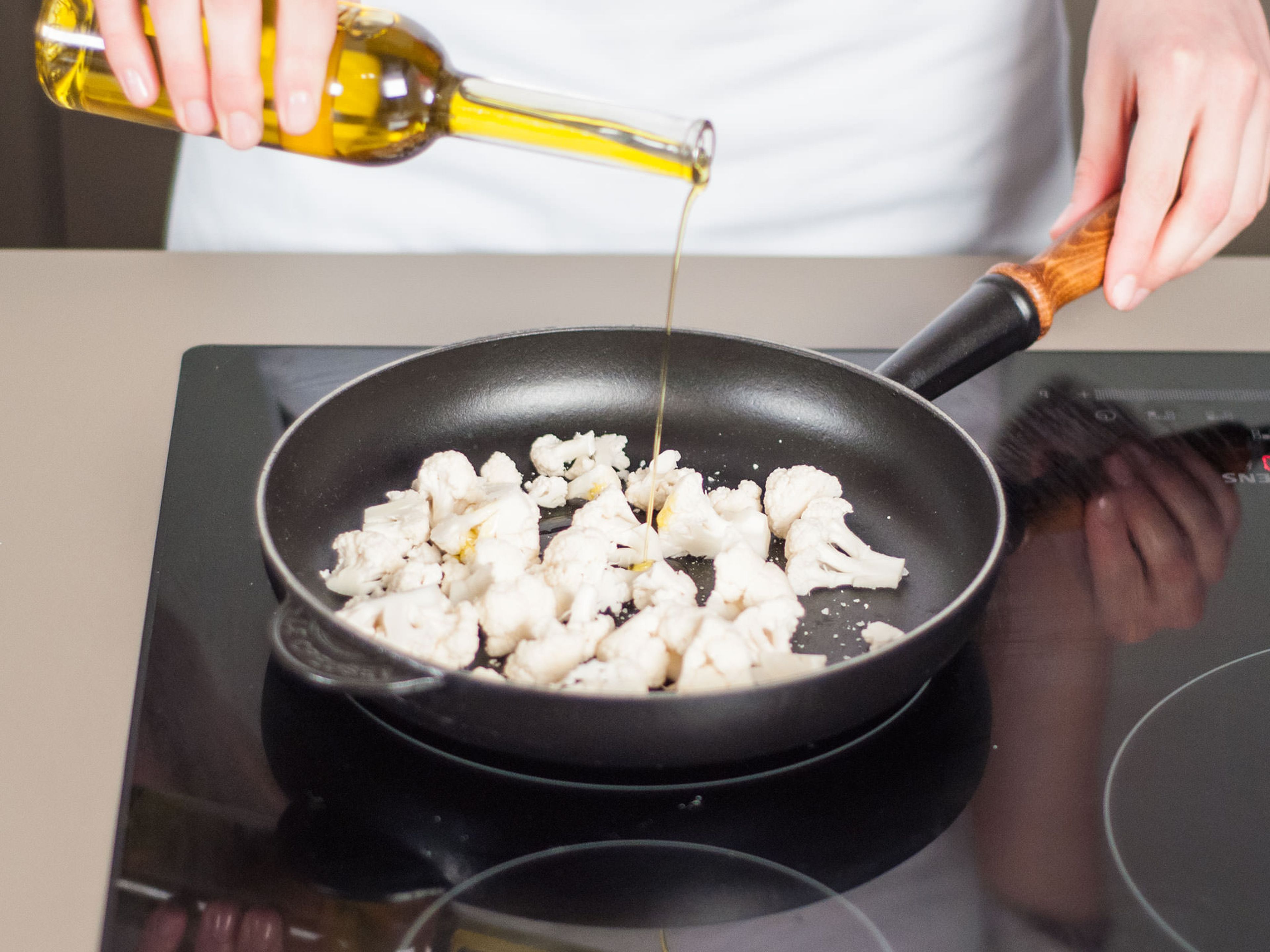 Blumenkohl in eine ofenfeste Pfanne geben. Olivenöl hinzugeben und mit Salz und Pfeffer würzen. Im Backofen bei 180°C ca. 10 Min. backen. Dann aus dem Backofen nehmen und beiseitestellen.
