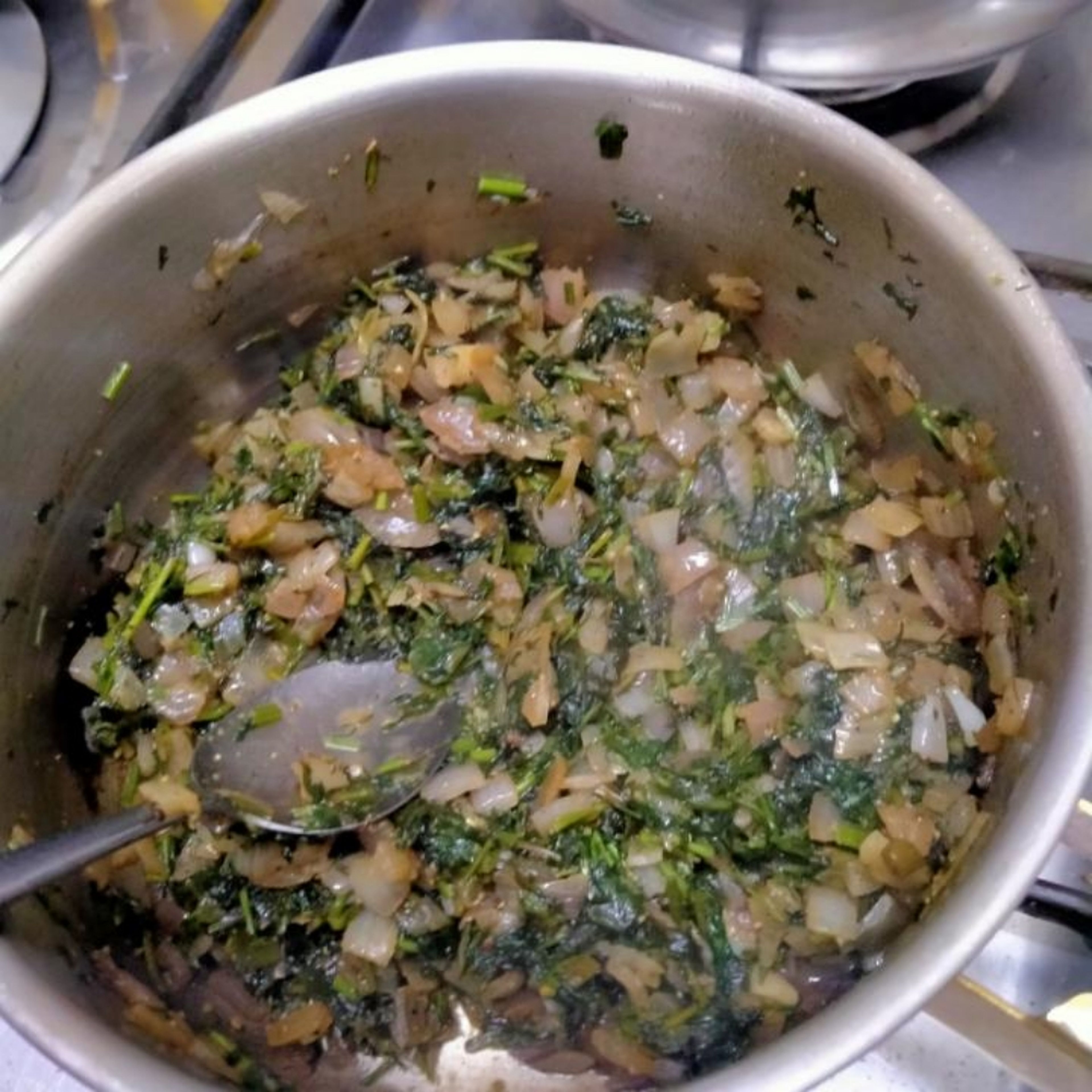 add chopped parsley, dill and cilantro one cup each and cook for about 2-3 minutes until reduced in volume then add ground coriander, black pepper, chilli flakes and salt 1 tsp each stir it for another minute and set a side and let it cool for 10 minutes. keep in mind you could add more salt later as you like
