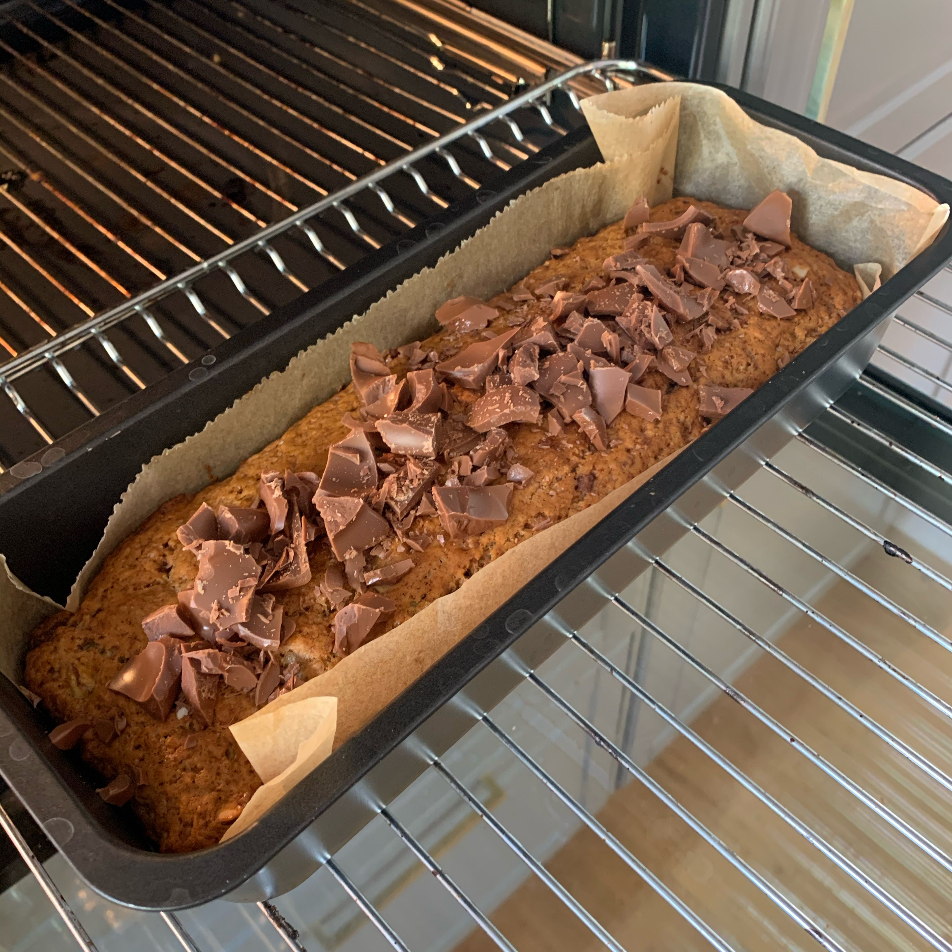Nach Ablauf der Zeit mit einem Holzstäbchen testen, ob der Kuchen durch ist. Dann restliche Schokolade darauf verteilen und bei geöffneter Tür einige Minuten im Ofen stehen lassen, damit die Stücke festkleben können. Fertig!