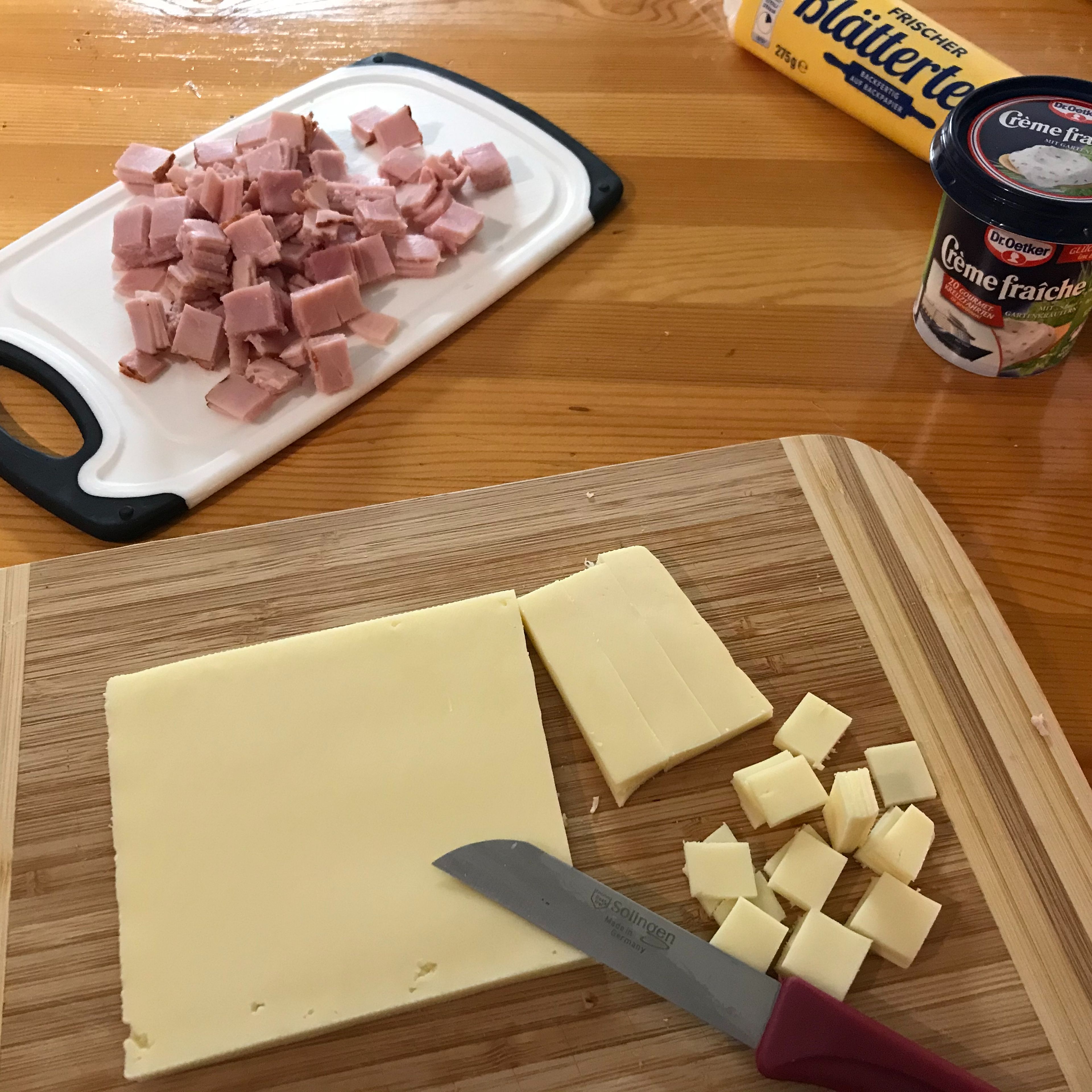 Den Kochschinken und den Käse in kleine Würfel/Quadrate schneiden.