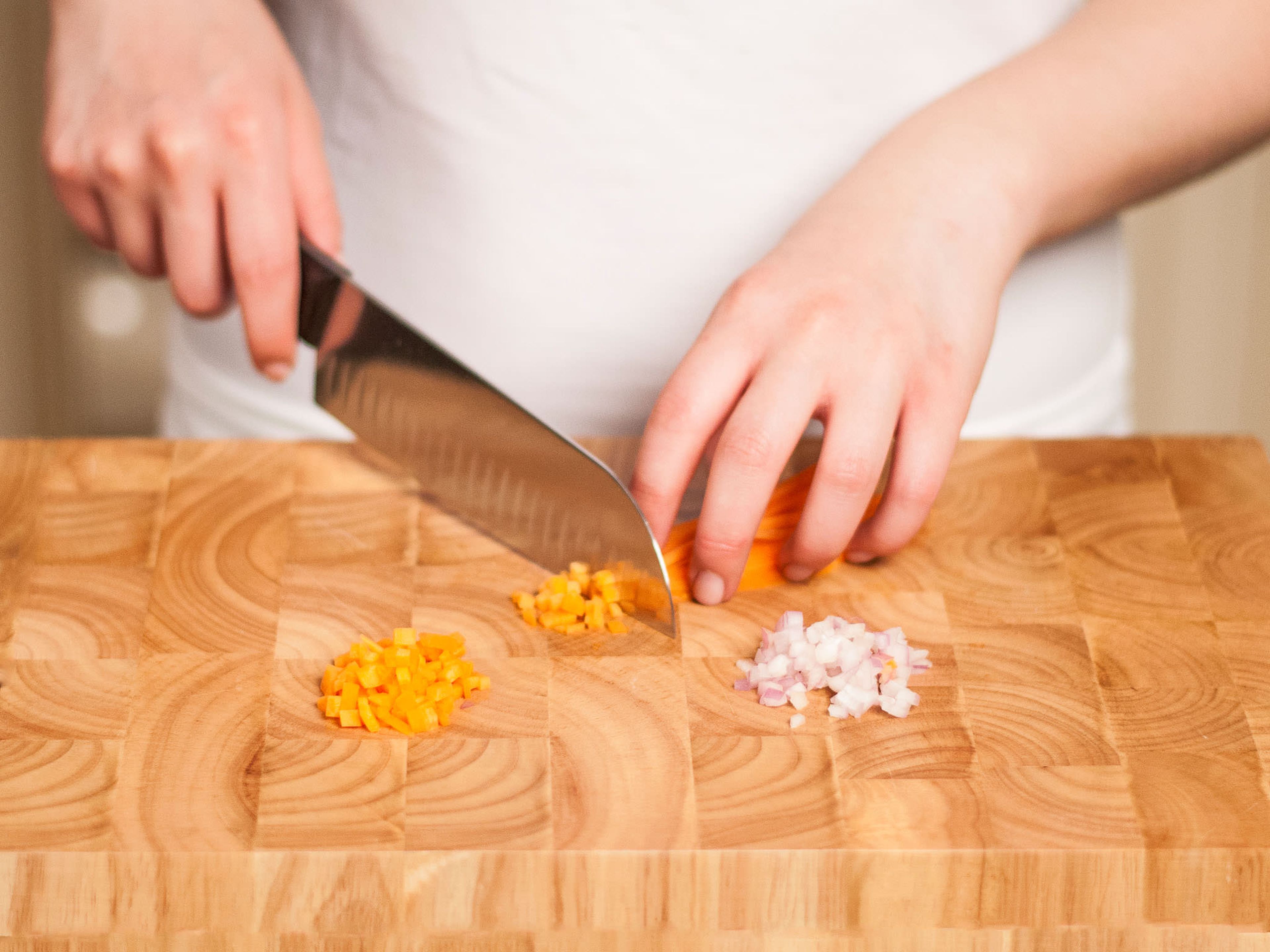 Knoblauch fein hacken. Zwiebel und Karotten schälen und fein würfeln.