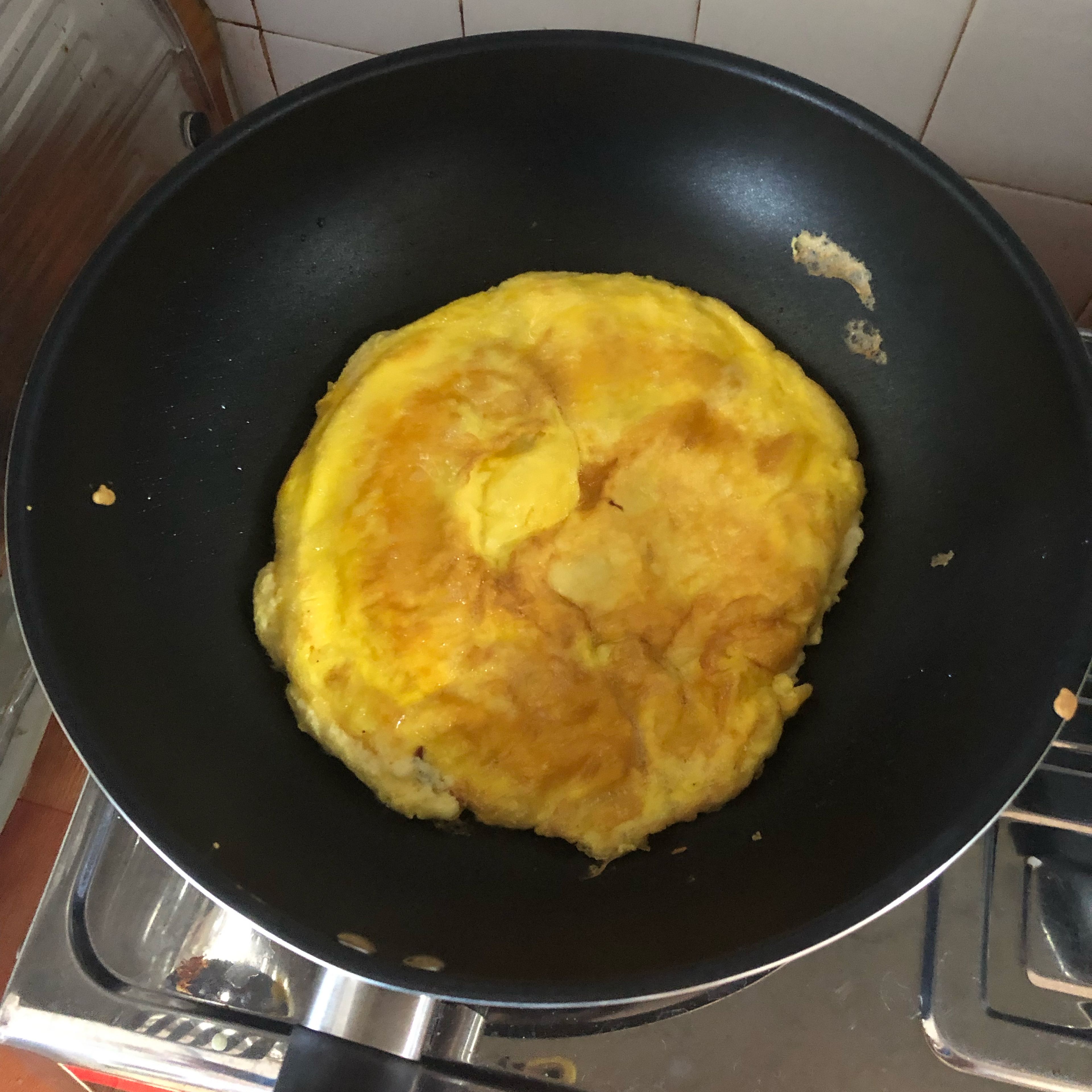 Add some oil into the frying pan and put it on medium heat. Pour the egg mixture in and flip the egg after the bottom has turn golden
