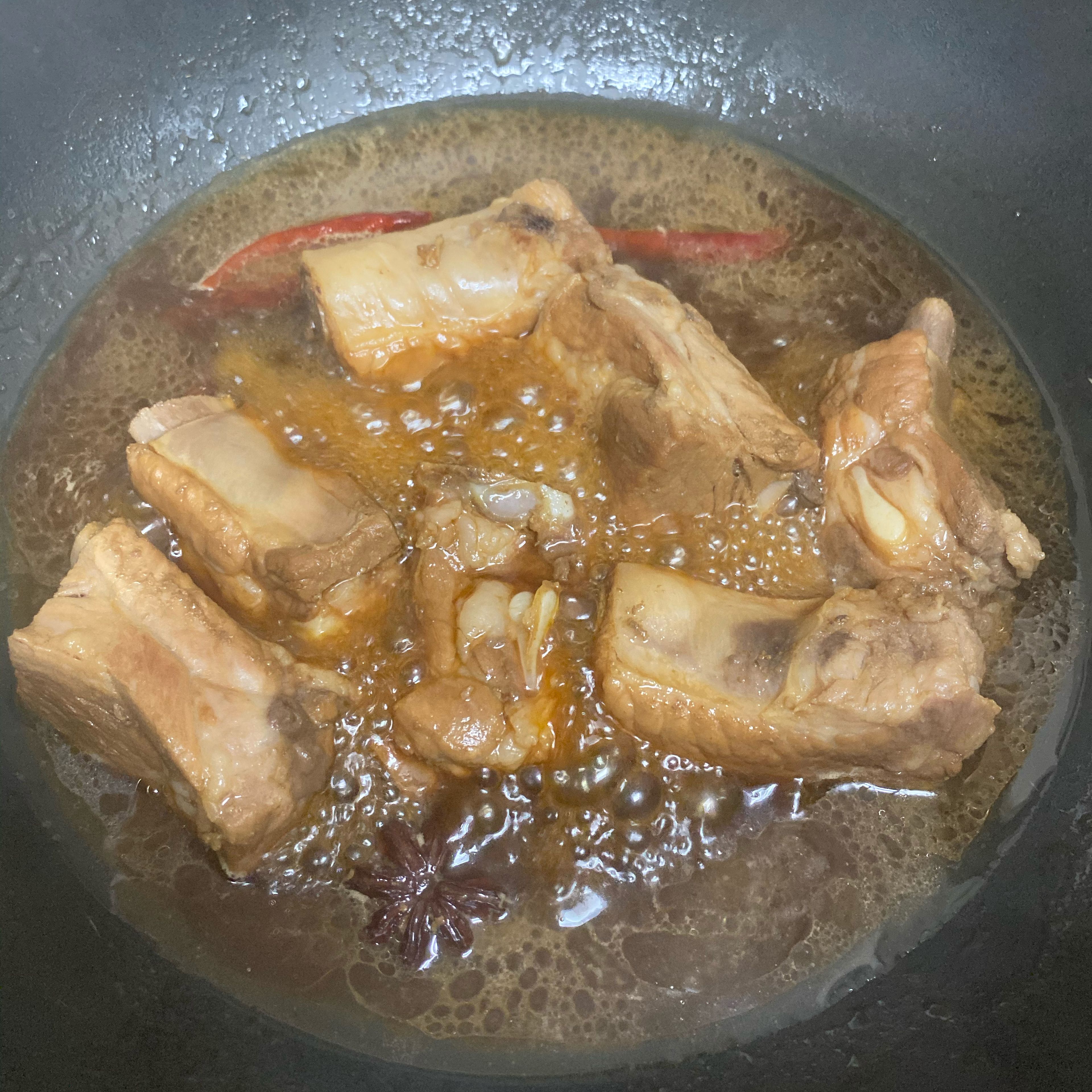 Remove the lid and turn the heat back to high. Carefully watch the water because it evaporates quite fast. Stir the ribs if needed in case they get sticky to the pot/wok. The ribs are done when there’s only a little broth left and it should be a bit sticky. Their color is also much darker.