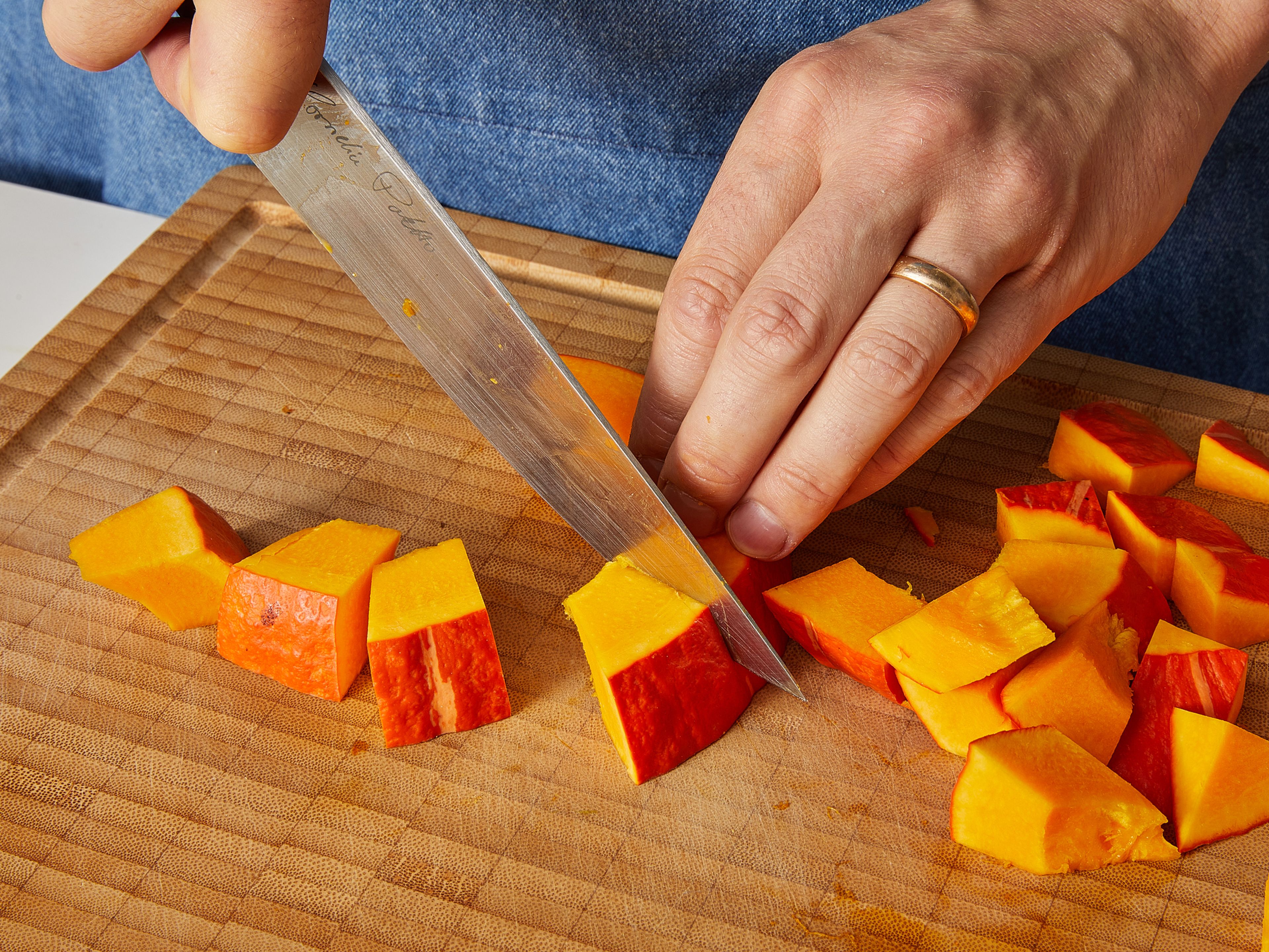 Preheat the oven to 200°C/390°F top/bottom heat. Cut pumpkin in half and scrape out the seeds with a spoon and discard (or wash and save for another use). Cut pumpkin into approx. 3 cm/ 1.2 in. cubes. Peel onions and cut into approx. 1 cm/ 0.4 in. wedges. Cut halloumi into approx. 2 cm/ 0.8 in., bite-sized cubes and pat dry.