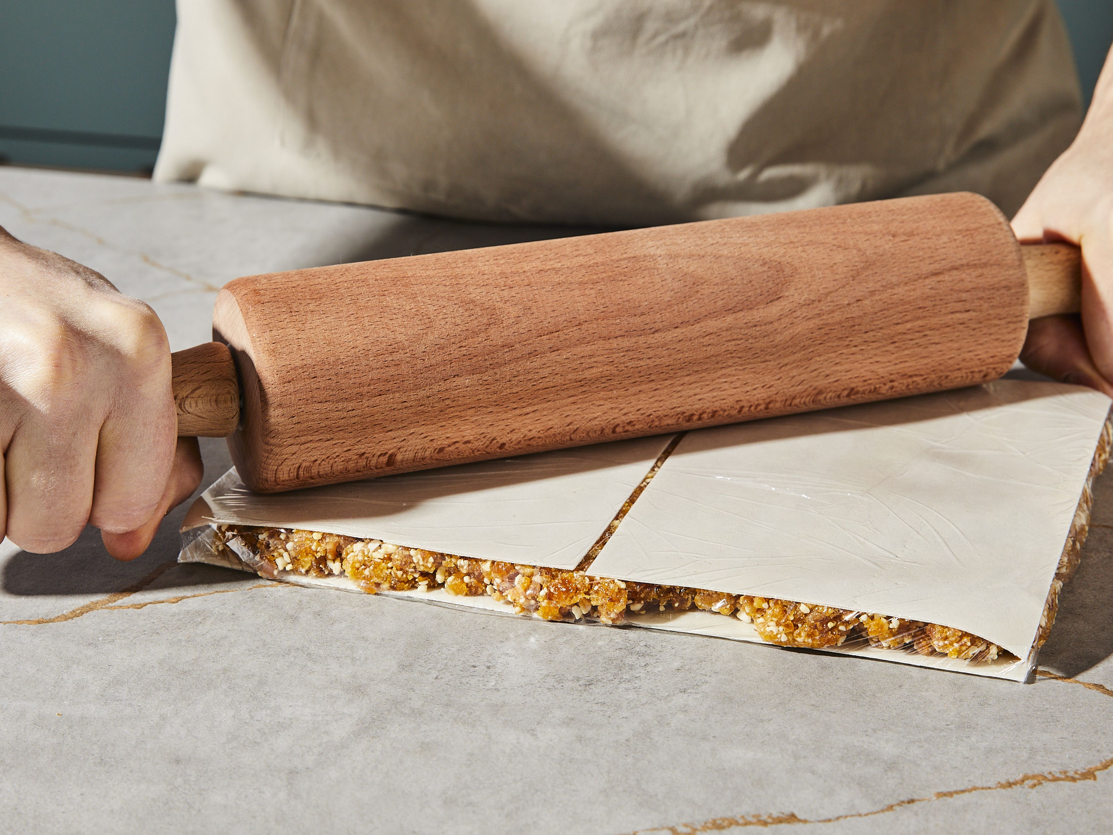 Die Folie an der Oberfläche entfernen und mit Oblaten bedecken. Jetzt auf ein Schneidebrett stürzen und die zweite Seite mit Oblaten belegen. Diese richtig fest andrücken, das geht am besten mit einem Rollholz. Ggf. wieder in Folie einpacken und 1 Stunde ruhen lassen. Anschließend in Riegel schneiden. Die Riegel halten bei Zimmertemperatur mindestens eine Woche, im Kühlschrank auch wesentlich länger.