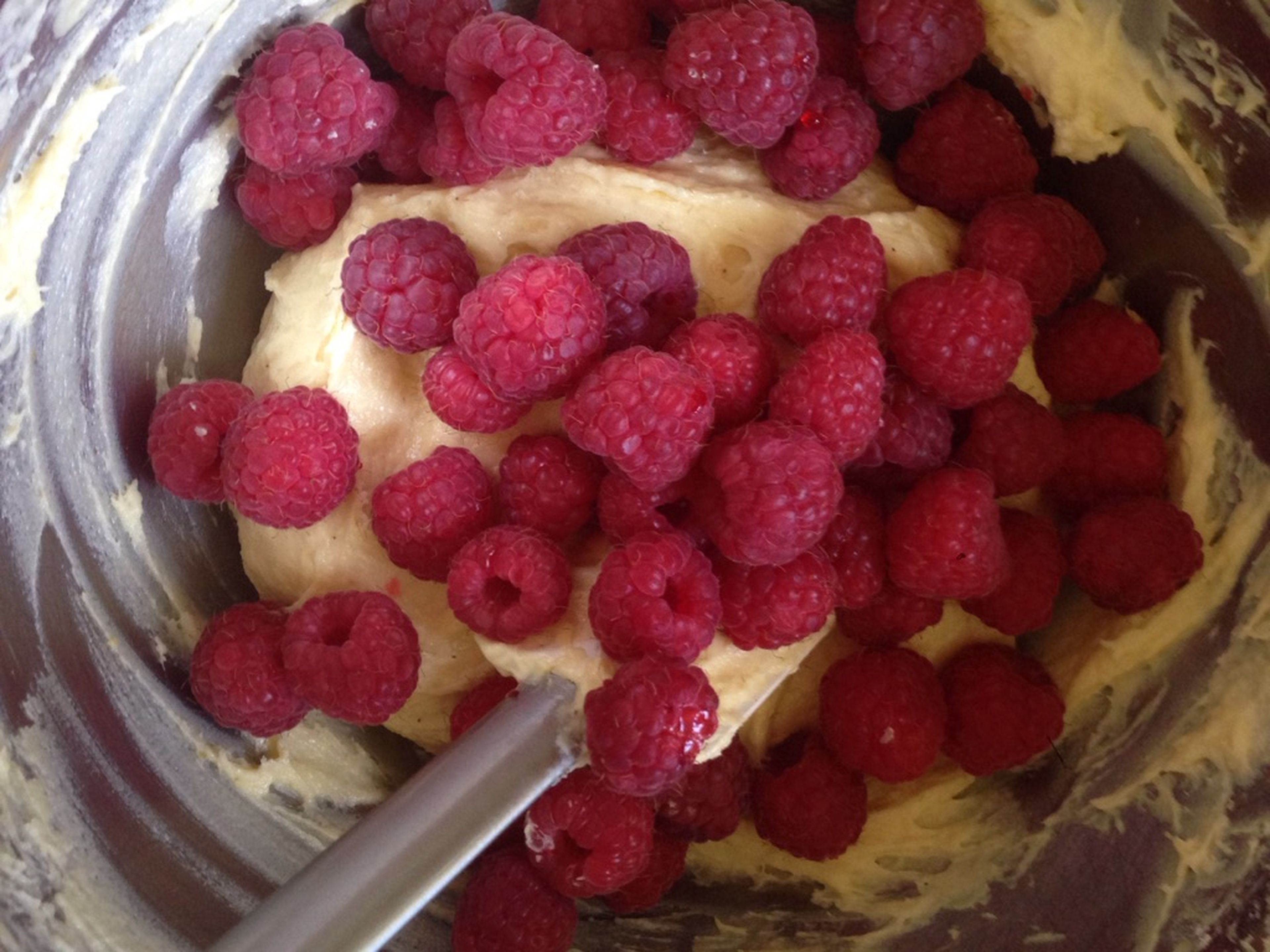 Add raspberries and stir carefully. Transfer to a muffin tin lined with muffin liners.