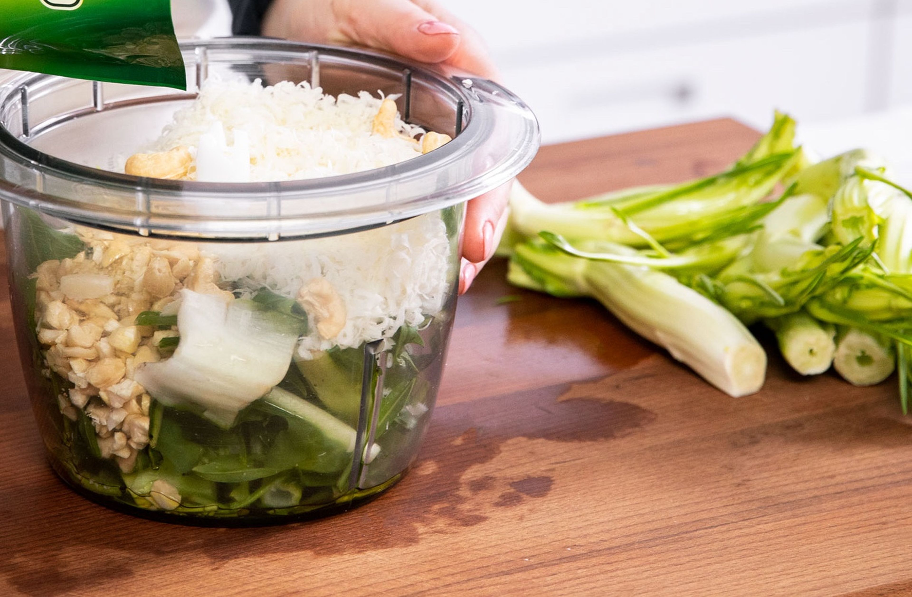 Set aside a few dandelion leaves for garnishing. Cut remaining green dandelion leaves from the stems. Finely slice the stems and set aside. Roughly chop dandelion leaves and cashews. Add the leaves, cashews, half of the garlic cloves, juice of half of the lime, grated Parmesan cheese, and some of the olive oil to a food processor. Blend until a creamy pesto forms and season with salt and pepper to taste. Set the pesto aside.
