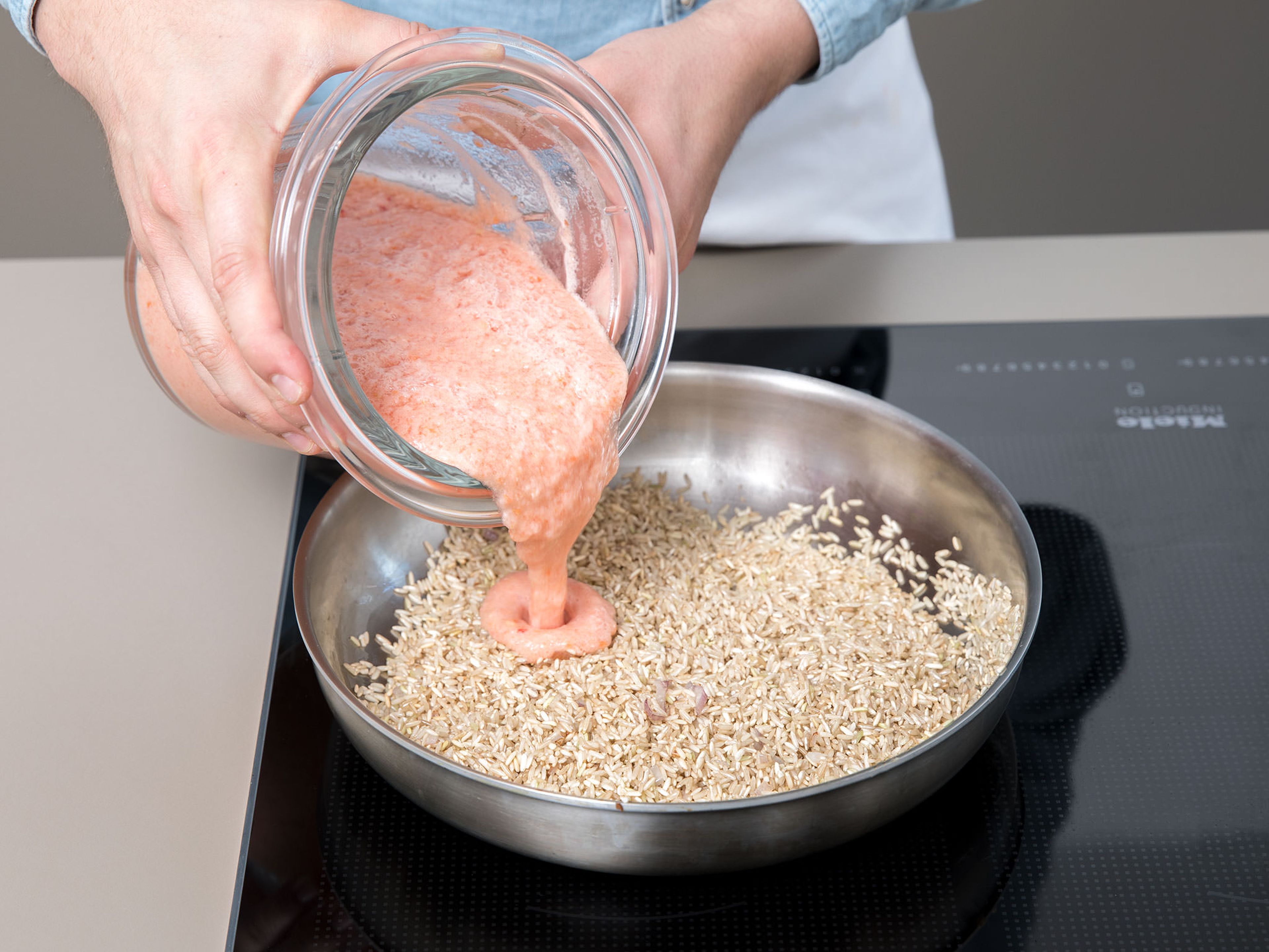 Nun wird der Reis gebraten und gedünstet. Zunächst etwas Zwiebel in Öl anbraten, dann den Reis hinzugeben und ca. 2 Min. braten. Die Tomatensoße dazu geben, aufkochen und so lange köcheln lassen, bis der Reis gar ist.