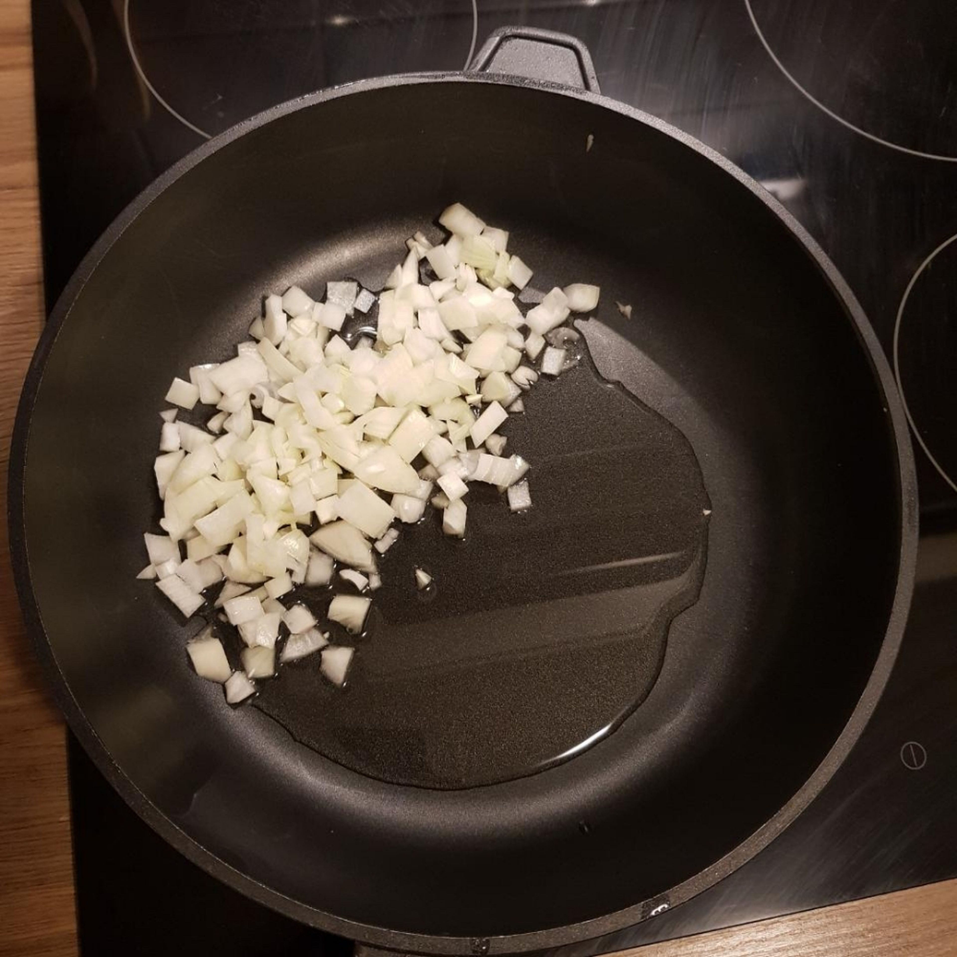  In einer tiefen Pfanne das Öl langsam erhitzen und die Zwiebeln glasig anschwitzen. Anschließend den geschnittenen Kohl zugeben und mit anschwitzen.