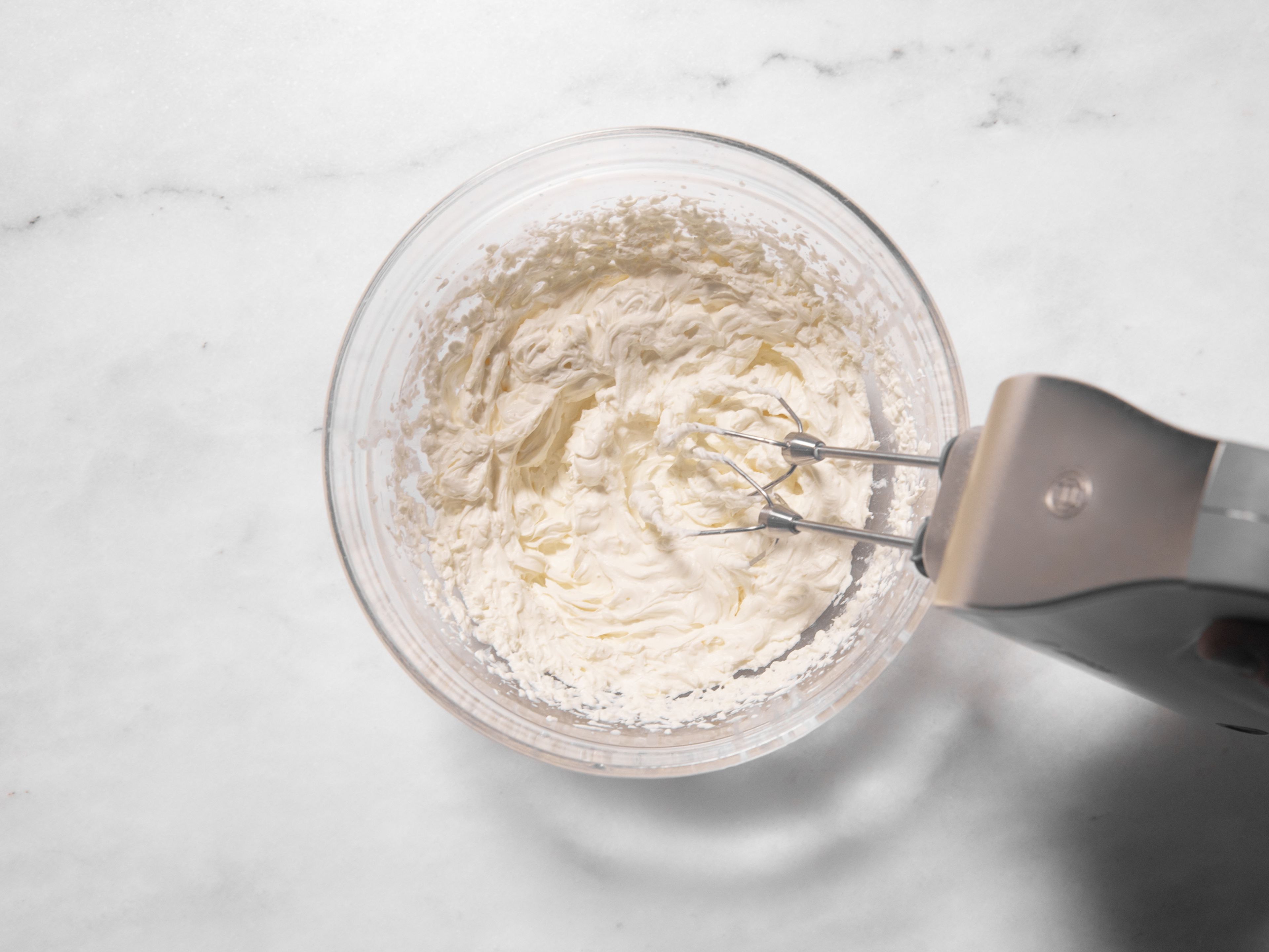 Add mascarpone, heavy cream, vanilla sugar, and half the lemon zest to a large bowl and beat with a hand mixer with beaters until fluffy and light.