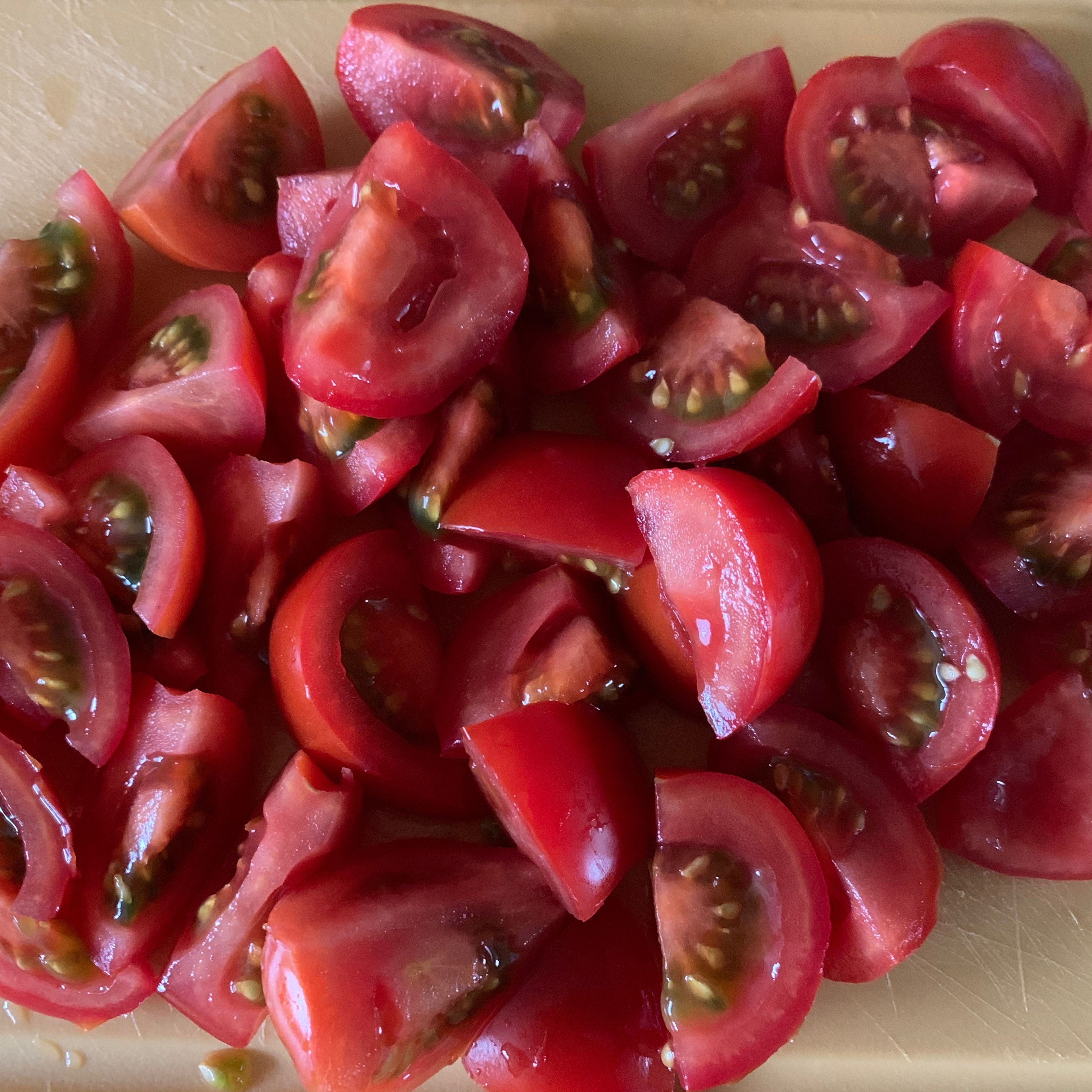 Nun die Tomaten vierteln und den Knoblauch fein hacken.
