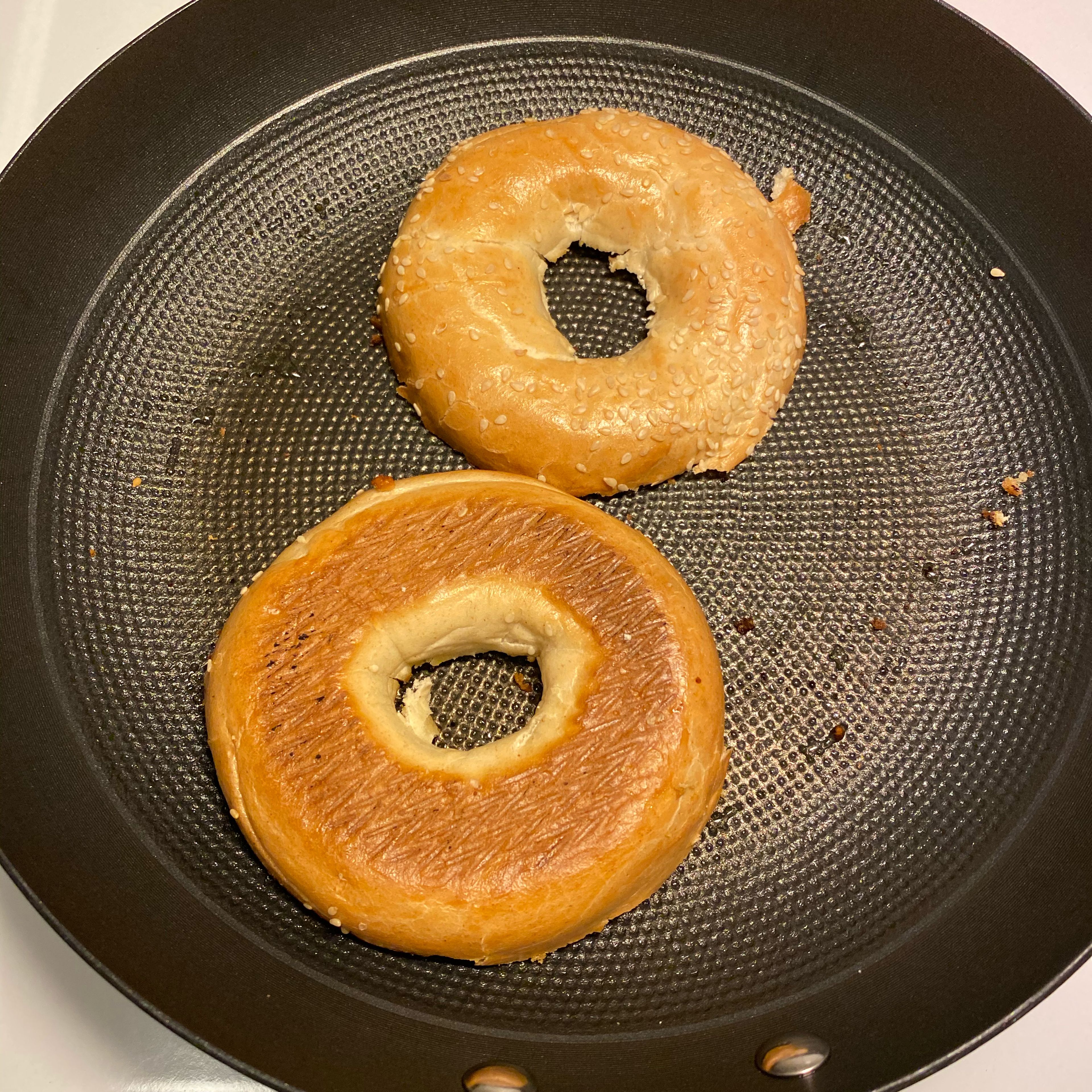 Slice the bagel into half and put oil in a pan and toast it a little bit.