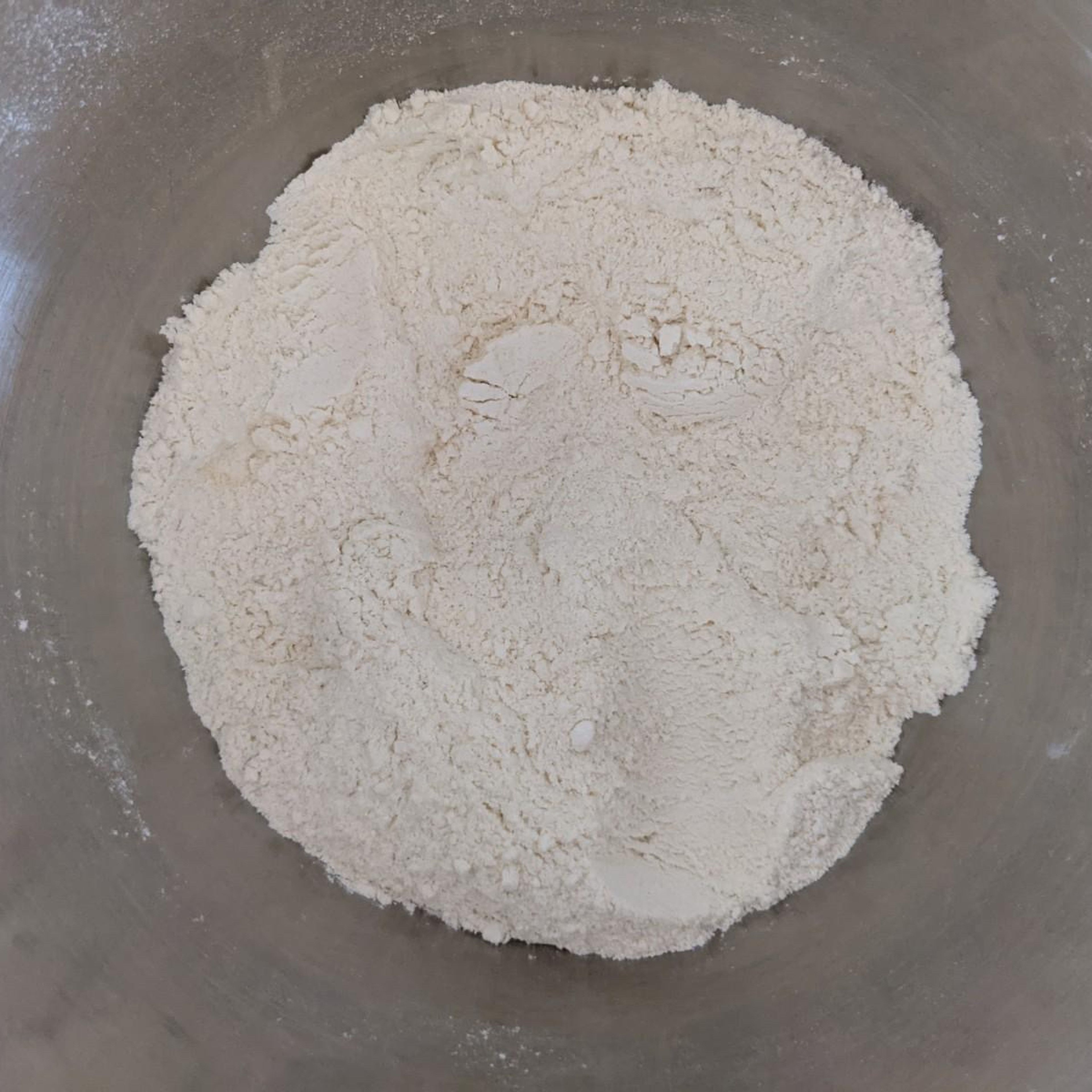 Hole dir eine Rührschüssel (falls möglich mit Knethaken, ansonsten kann man auch mit der Hand rühren). Füge dann Mehl, Hartweizengrieß und 1/2 TL Salz hinzu. Vermische dies nun mit einem Löffel