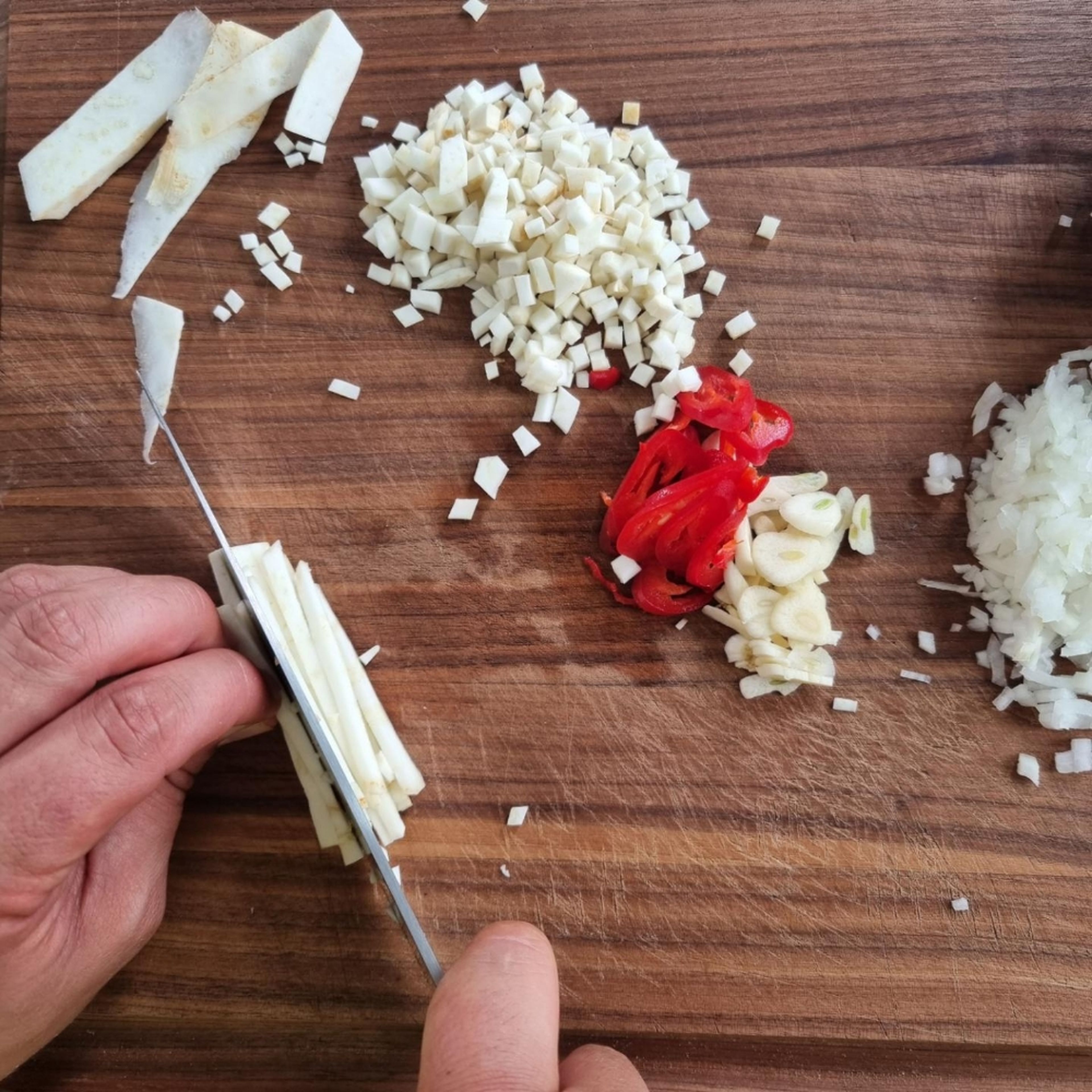 Cook the soy granules according to package directions and pat them dry.
Finely dice the celery root, garlic and onion. Cut the chili into slices.