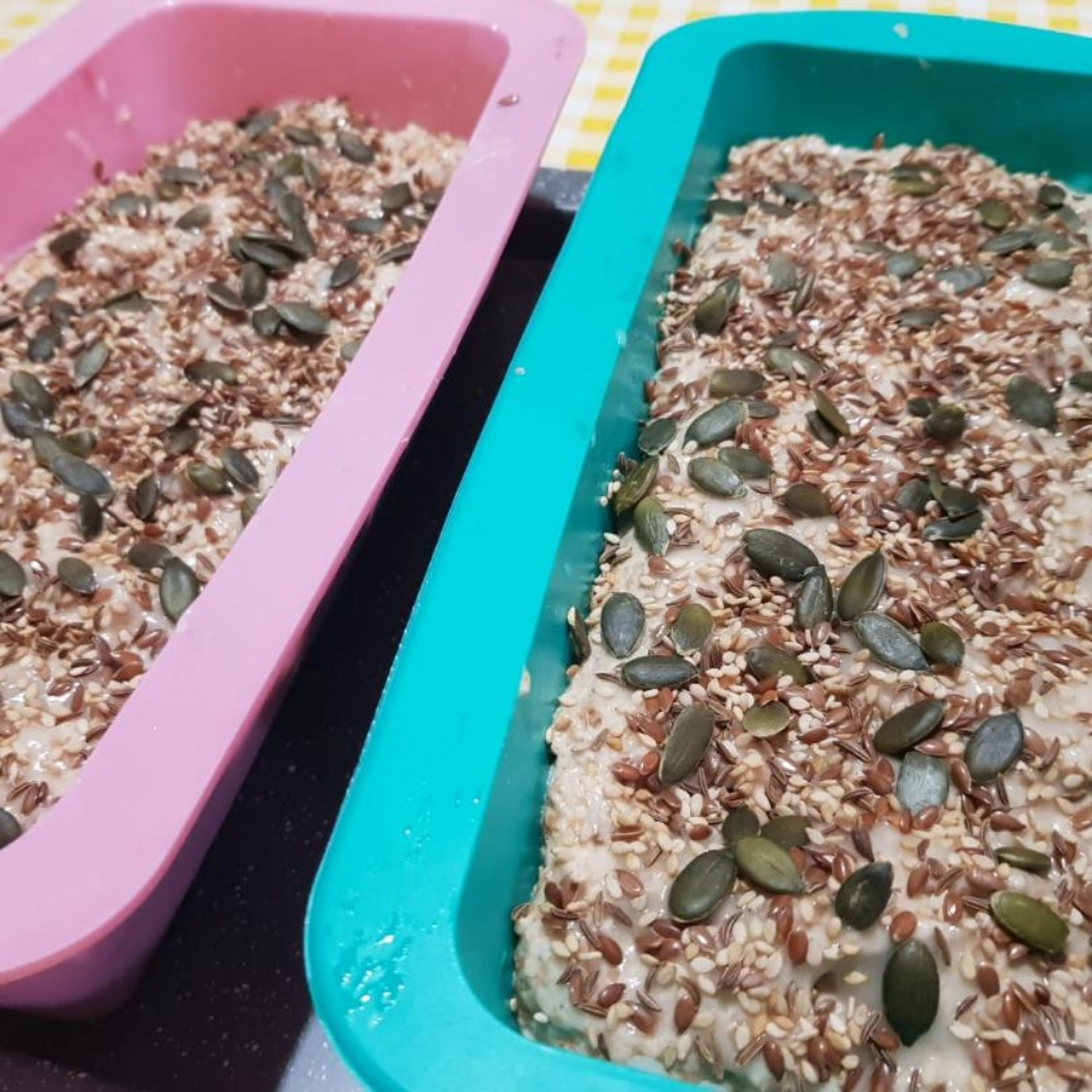 When the second time the dough rises, mix it again, and put it in the mold. Cover it with the mix of water and dough, and coat it with the layer of seeds. Let it rest for another 10 minutes before putting in the oven.