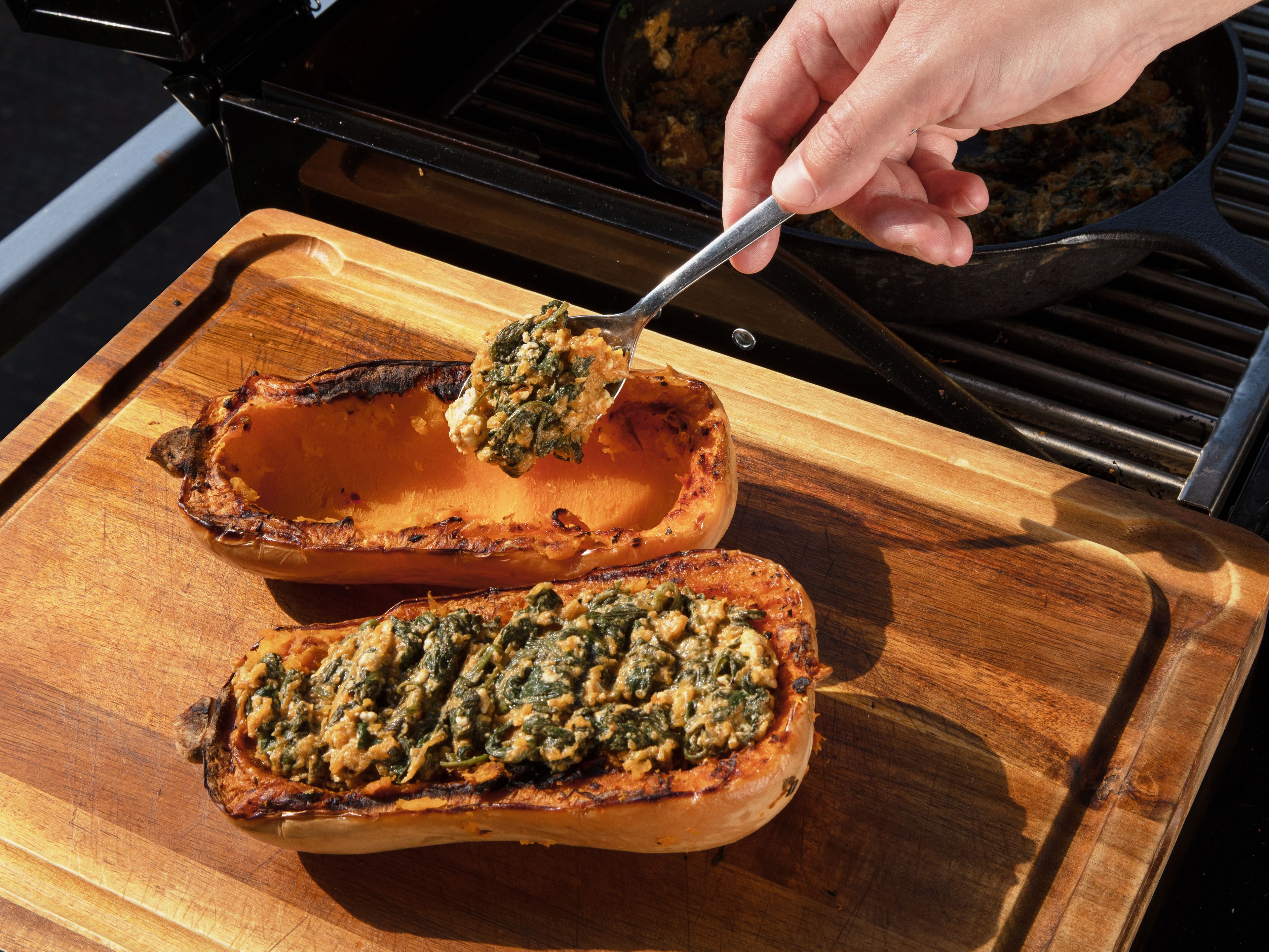 Nach der Garzeit die Kürbishälften vom Grill nehmen und kurz abkühlen lassen. Mit einem Löffel das Fruchtfleisch herauslösen, dabei einen Rand von ca. 1–1,5 cm stehen lassen. Das herausgelöste Fruchtfleisch unter die Spinat-Feta-Mischung rühren und dann alles zurück in die Kürbishälften füllen.