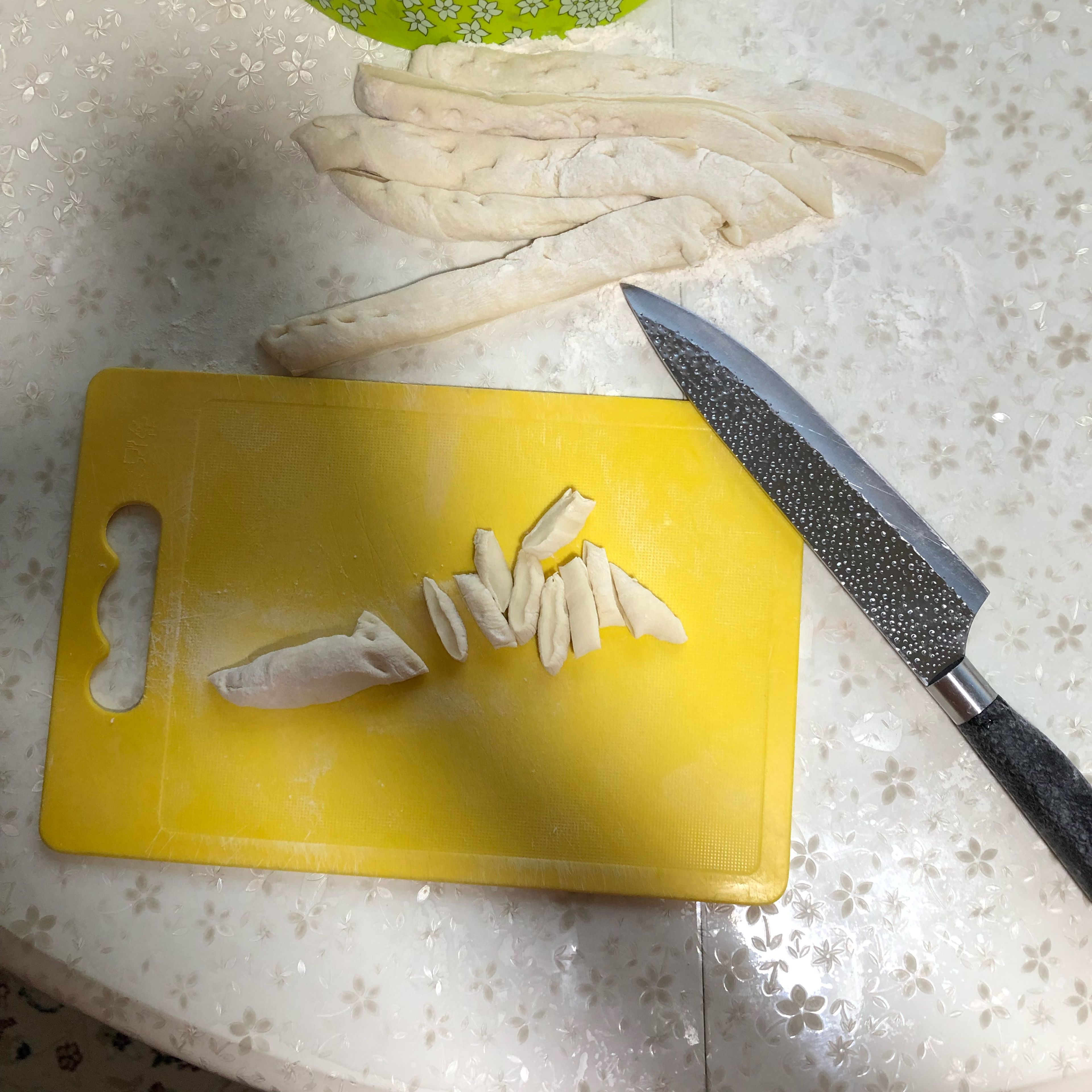 Get back to our dough and cut it into 3 equal parts. Roll out each parts with a rolling pin, to approx. 1 cm thick. Then cut them into 2 cm wide stripes. Cut each stripe crosswise into small pieces, these small dough pieces will be future galnash.
