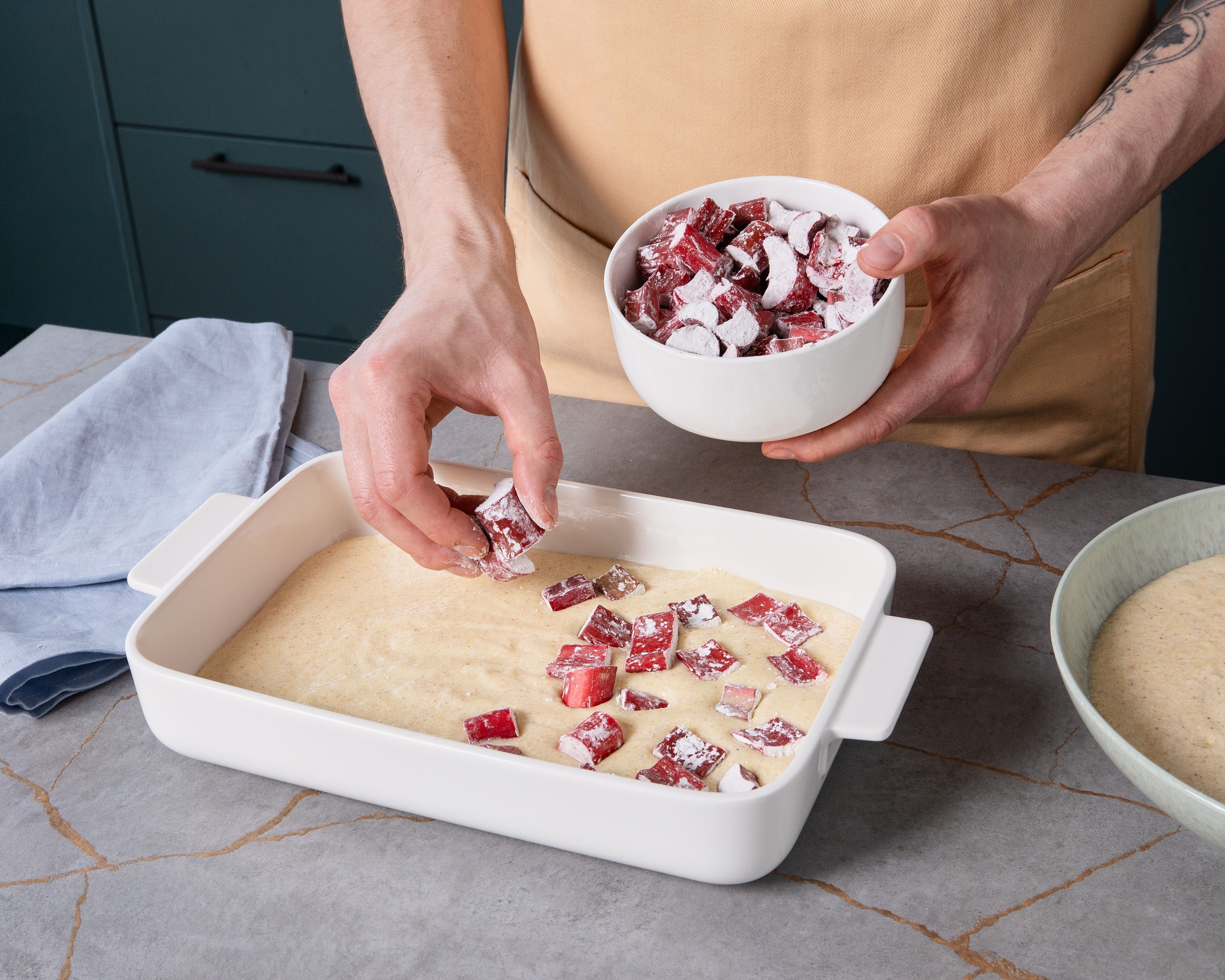 In a second large bowl, beat egg whites with a hand mixer until stiff. Gradually add remaining sugar while beating. Gently fold whipped egg whites into the semolina mixture. Pour half of the finished mixture into the baking dish and top with half of the rhubarb. Add the remaining mixture as a second layer and scatter the rest of the rhubarb on top. Bake semolina casserole in the preheated oven for approx. 40 min. until golden brown. Let cool for approx. 15 min. and serve warm with a dusting of powdered sugar.