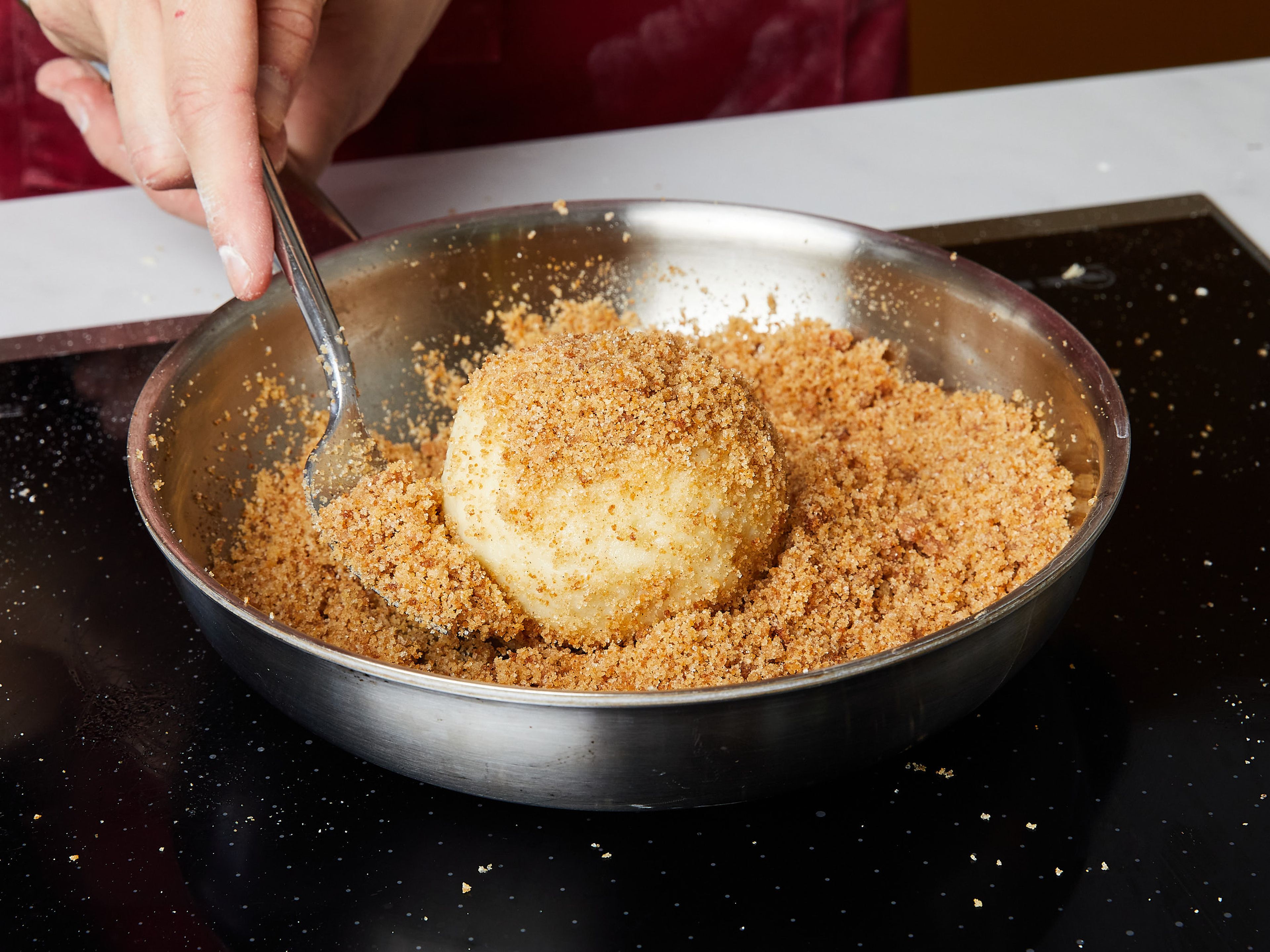 Meanwhile, melt the butter in a frying pan. Add breadcrumbs, sugar and cinnamon and fry until golden brown. Remove the dumplings from the water with the help of a cooking spoon, drain well and then roll in the butter-cinnamon crumbs. Sprinkle with a little powdered sugar and serve while still warm.