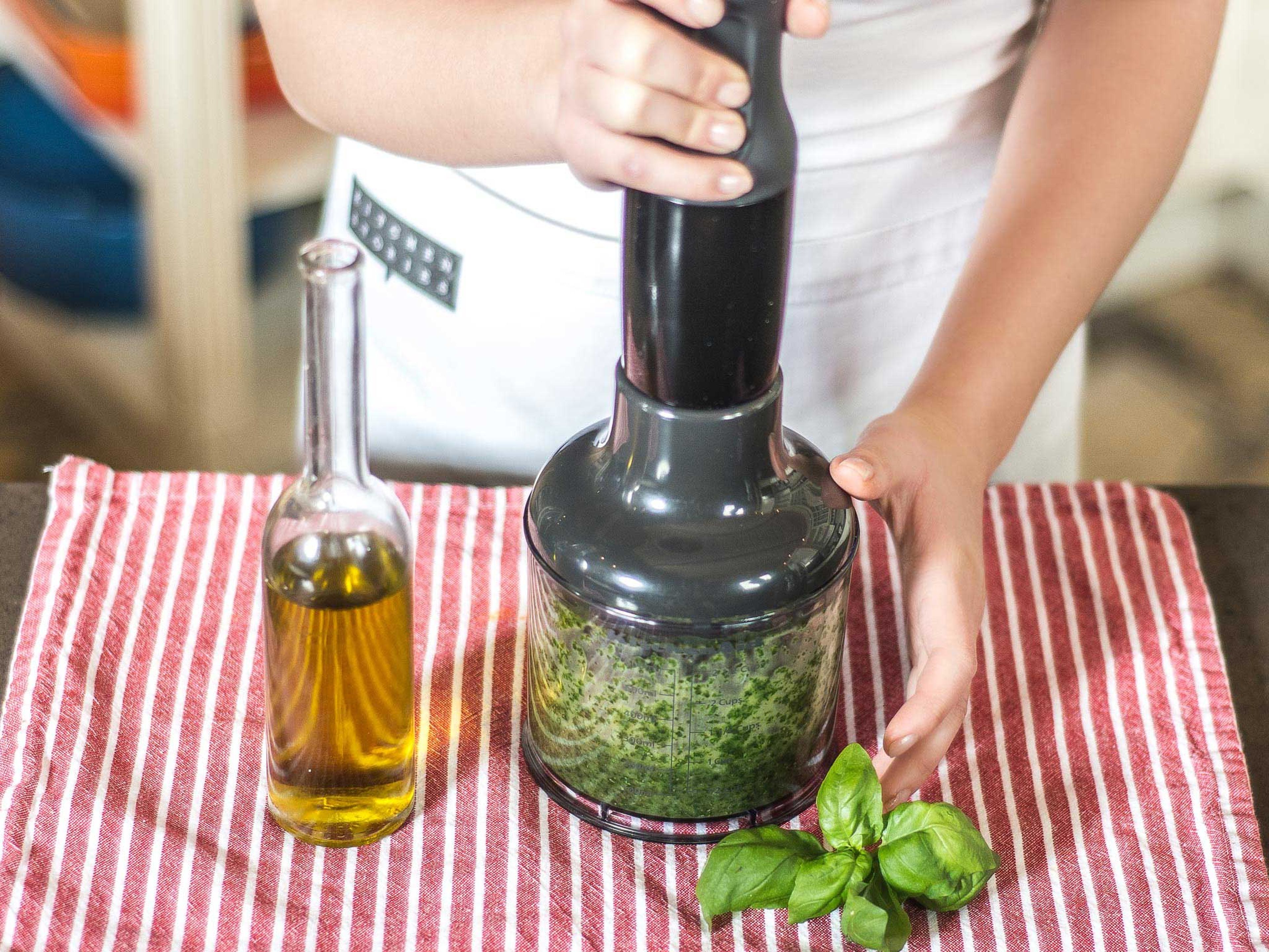 Für das Pesto Basilikum waschen, trocknen und in einer Küchenmaschine mit Pflanzenöl und Salz zerkleinern.