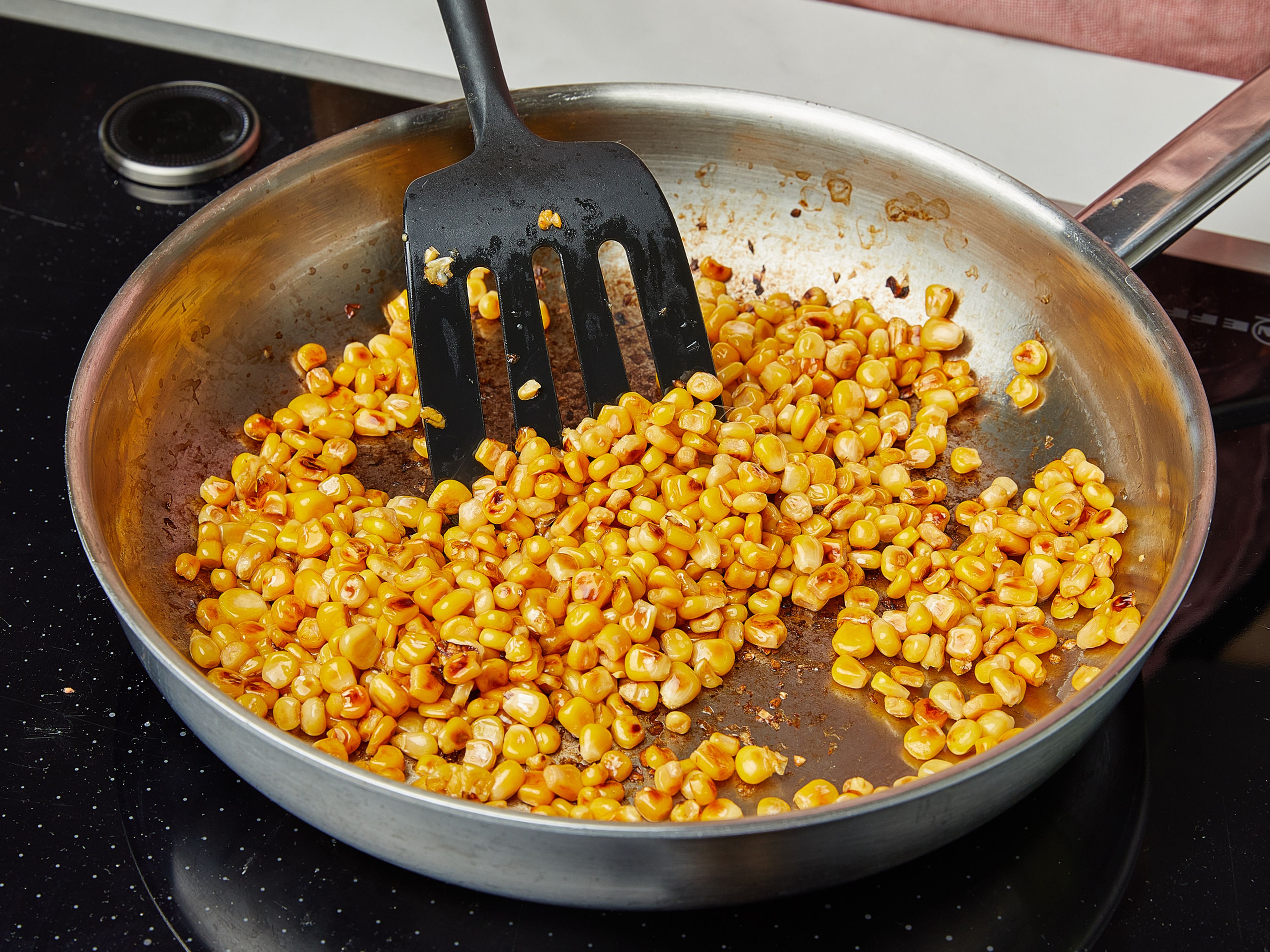 In a frying pan, add corn kernels, heat over medium-low heat until the water is evaporated. Then add olive oil, turn up the heat, and fry the corn kernels until browned or charred. Remove and set aside.