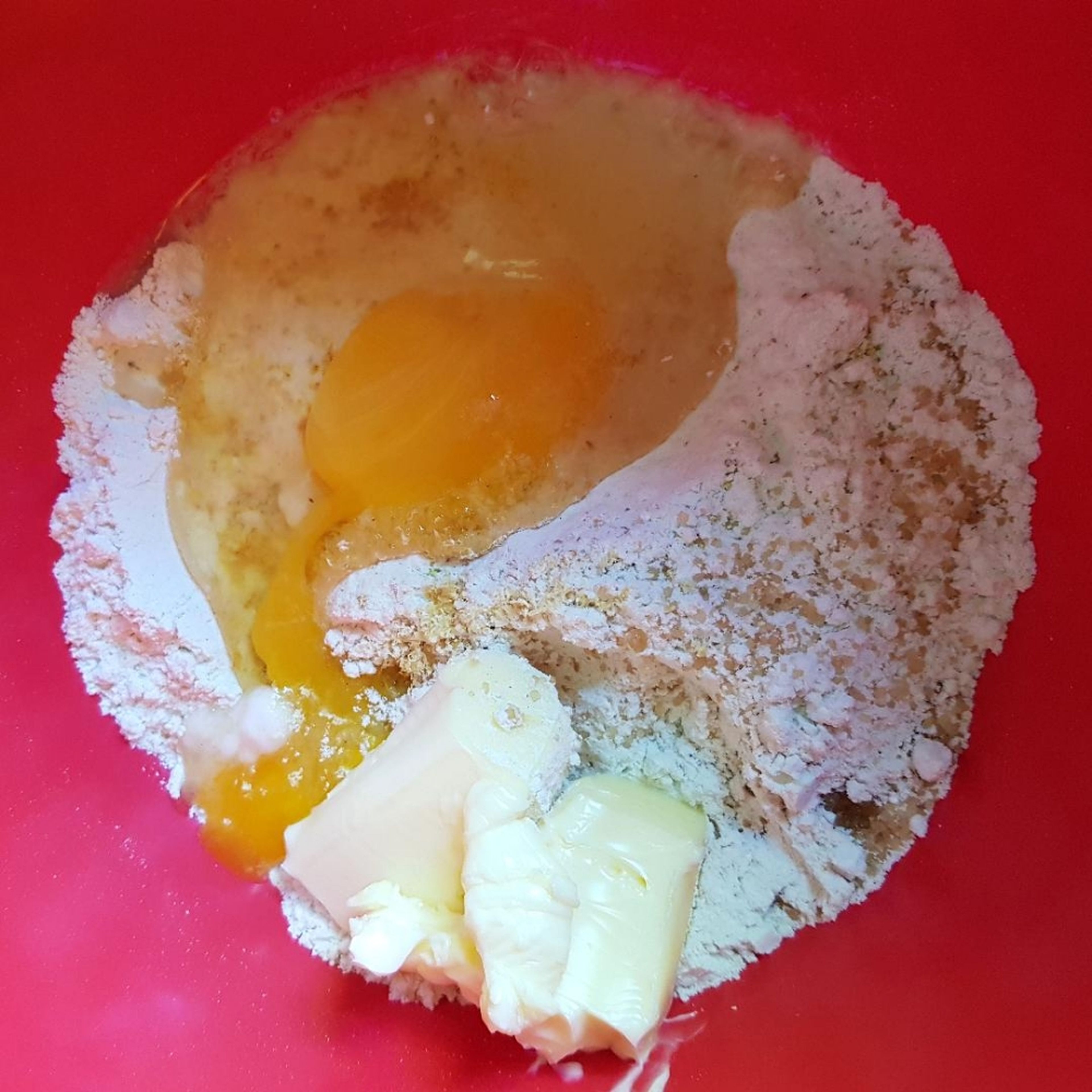 Für den Boden des Kuchens Teile des Mehls, Zucker, Butter (weich), das Ei, Backpulver und den Abrieb einer Zitrone mithilfe eines Rührgeräts vermengen, bis ein glatter Teig entsteht.