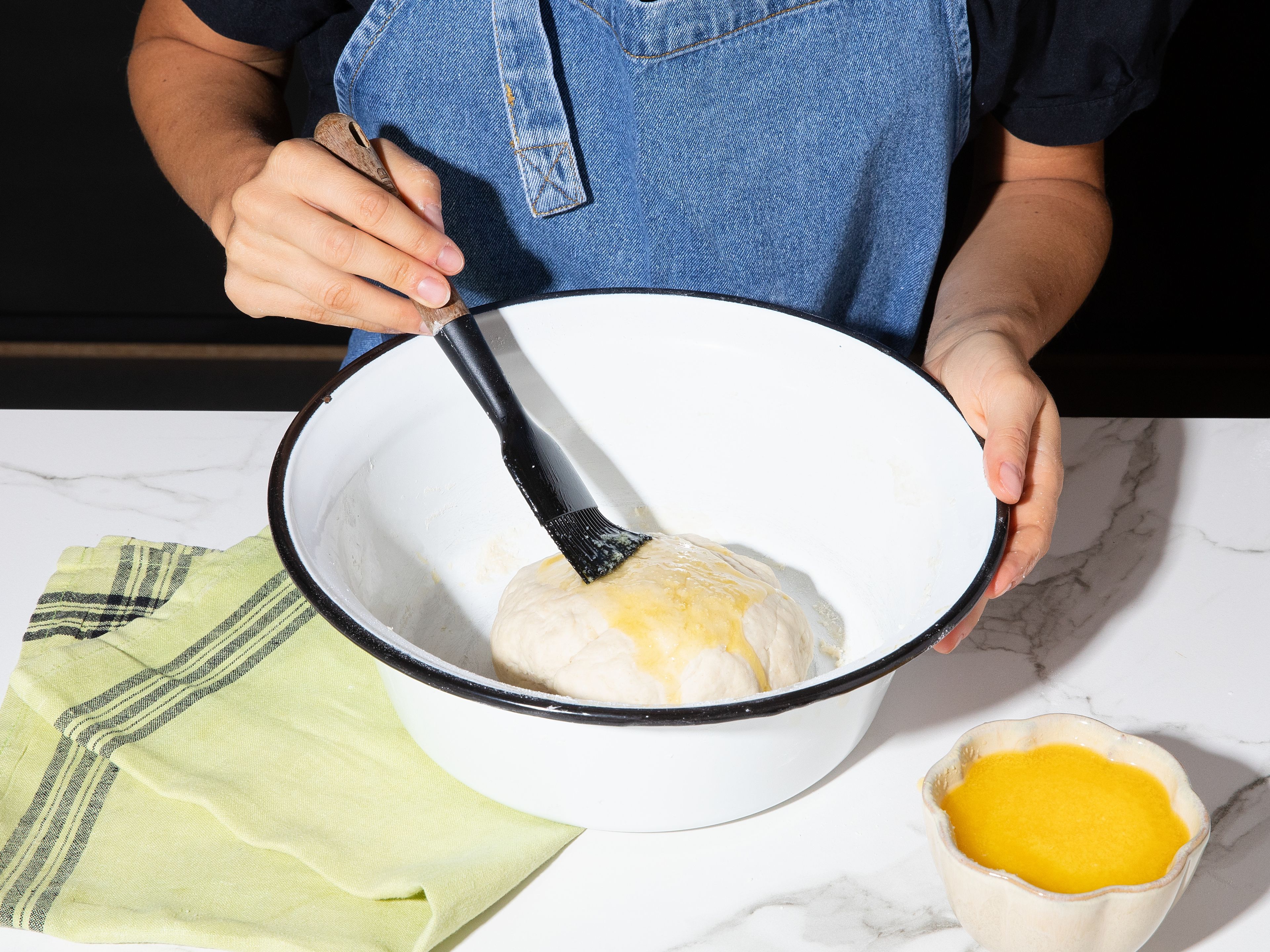 Für die Paratha-Brote Mehl mit einer Prise Salz vermengen. Ein wenig Ghee hinzufügen und mit den Händen einarbeiten, bis eine krümelige Masse entsteht. Eine Mulde in die Mitte drücken und das warme Wasser hineingießen. Alles zu einem glatten Teig verkneten. Mit etwas Ghee bestreichen und ruhen lassen, während die restlichen Komponenten zubereitet werden.