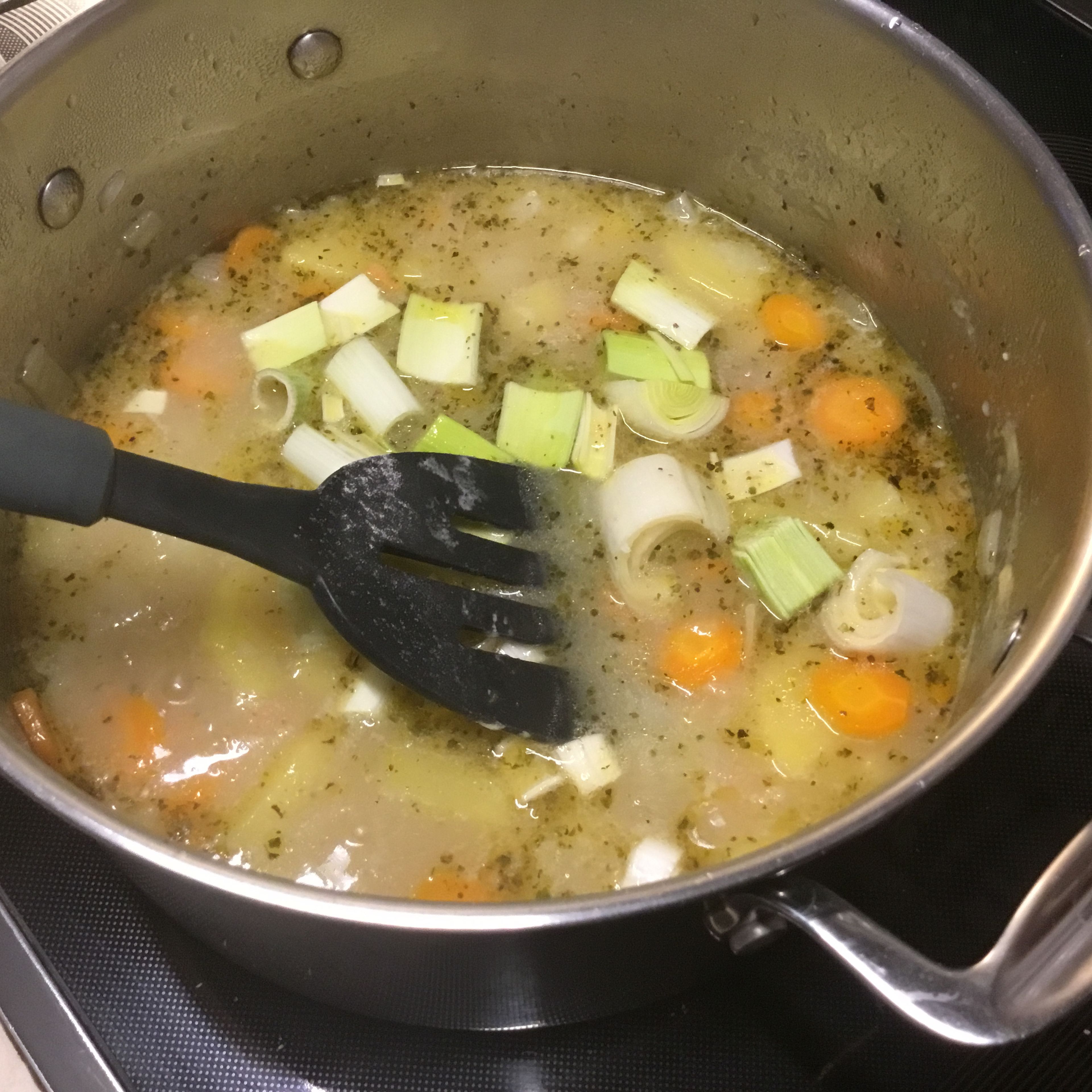 Den Lauch hinzufügen und die Suppe auf niedriger Temperatur köcheln lassen bis die Kartoffeln weich und die Suppe sämig wird.