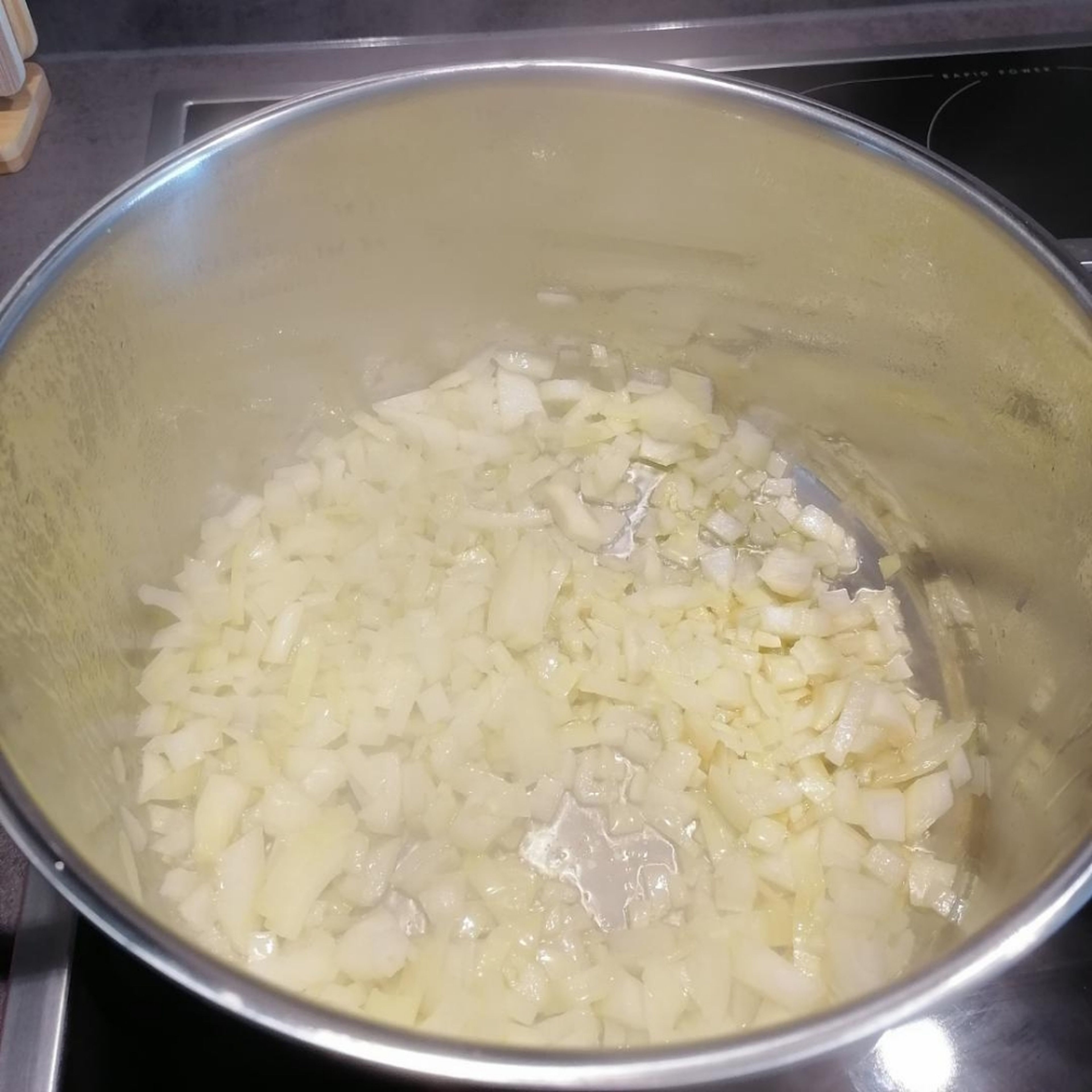 Die Knoblauchzehen und die Zwiebeln klein schneiden. Danach in einem großen Topf mit Olivenöl anbraten.