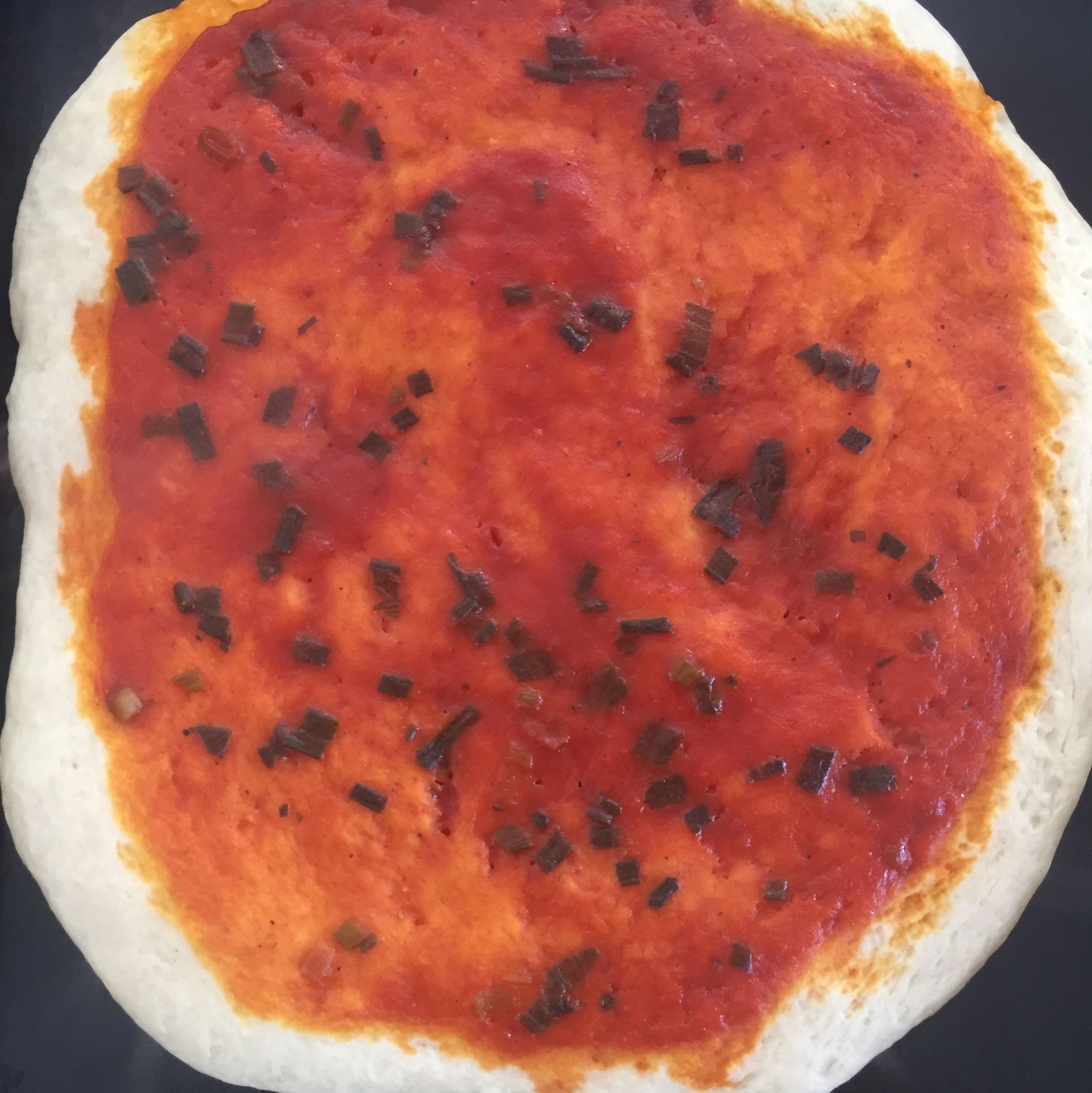 place rolled dough over a baking pan (make sure to oil it before.), and coat with tomato sauce, leaving a bit of a crust. Bake at 475 degrees Farenheit (220 degrees Celsius) for about twenty minutes, or until the bottom of the crust is golden brown.