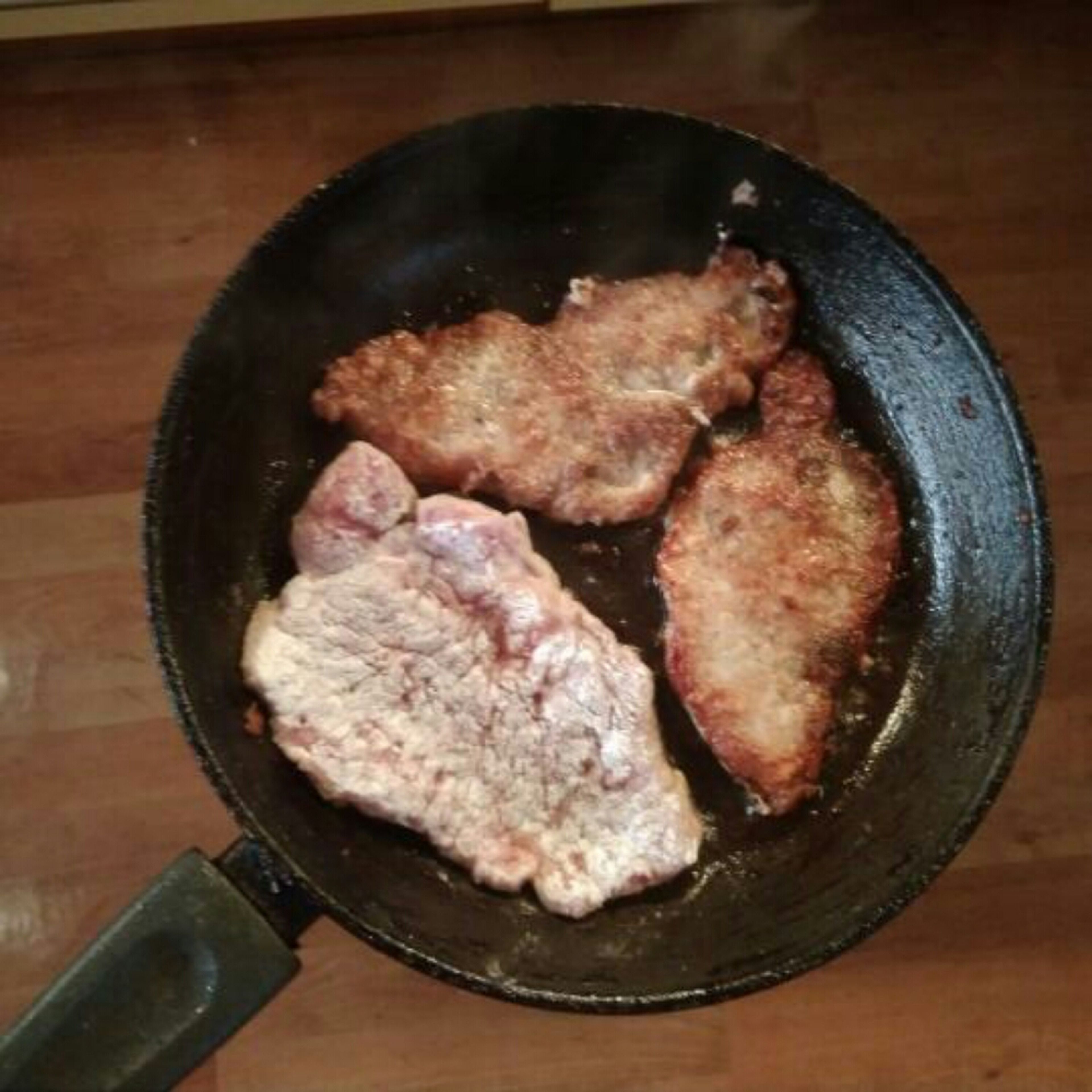 Meanwhile, fry the first slice of meat in a pan.