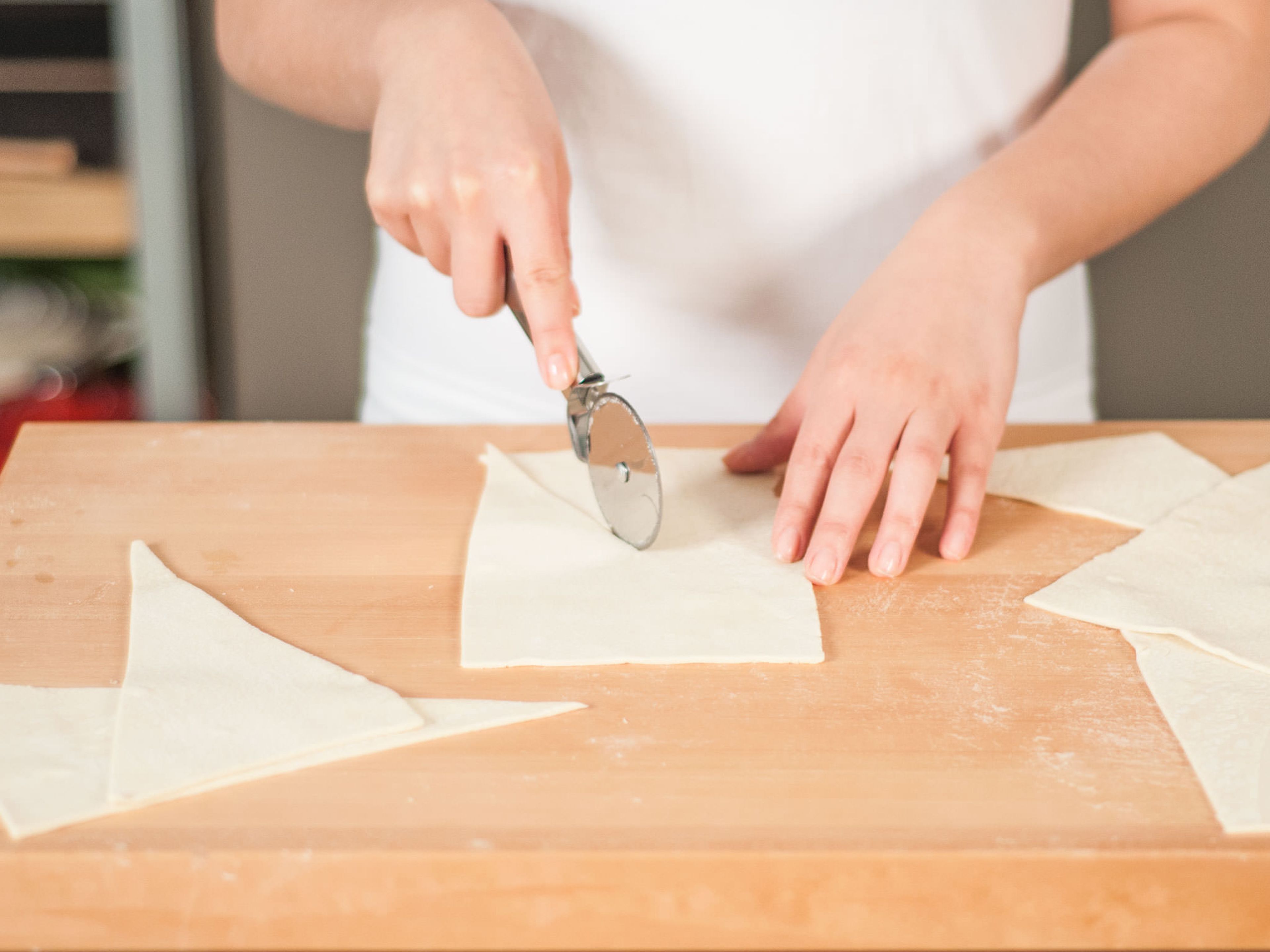 Roll out puff pastry and cut into long triangles.