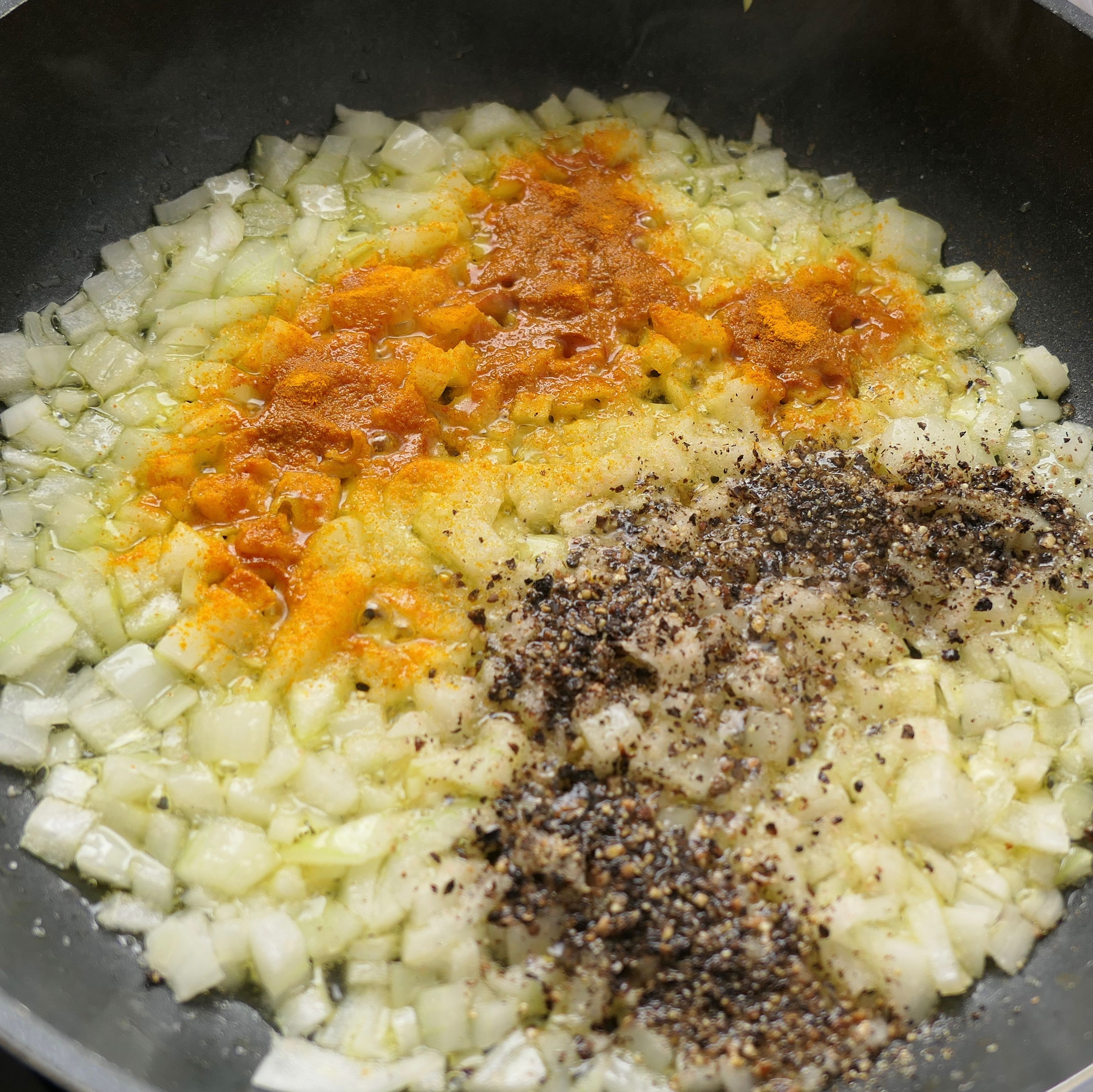 Würfle die Zwiebeln und brate sie in einer separaten Pfanne zusammen mit Salz, Kurkuma und Pfeffer an bis sie goldbraun sind.