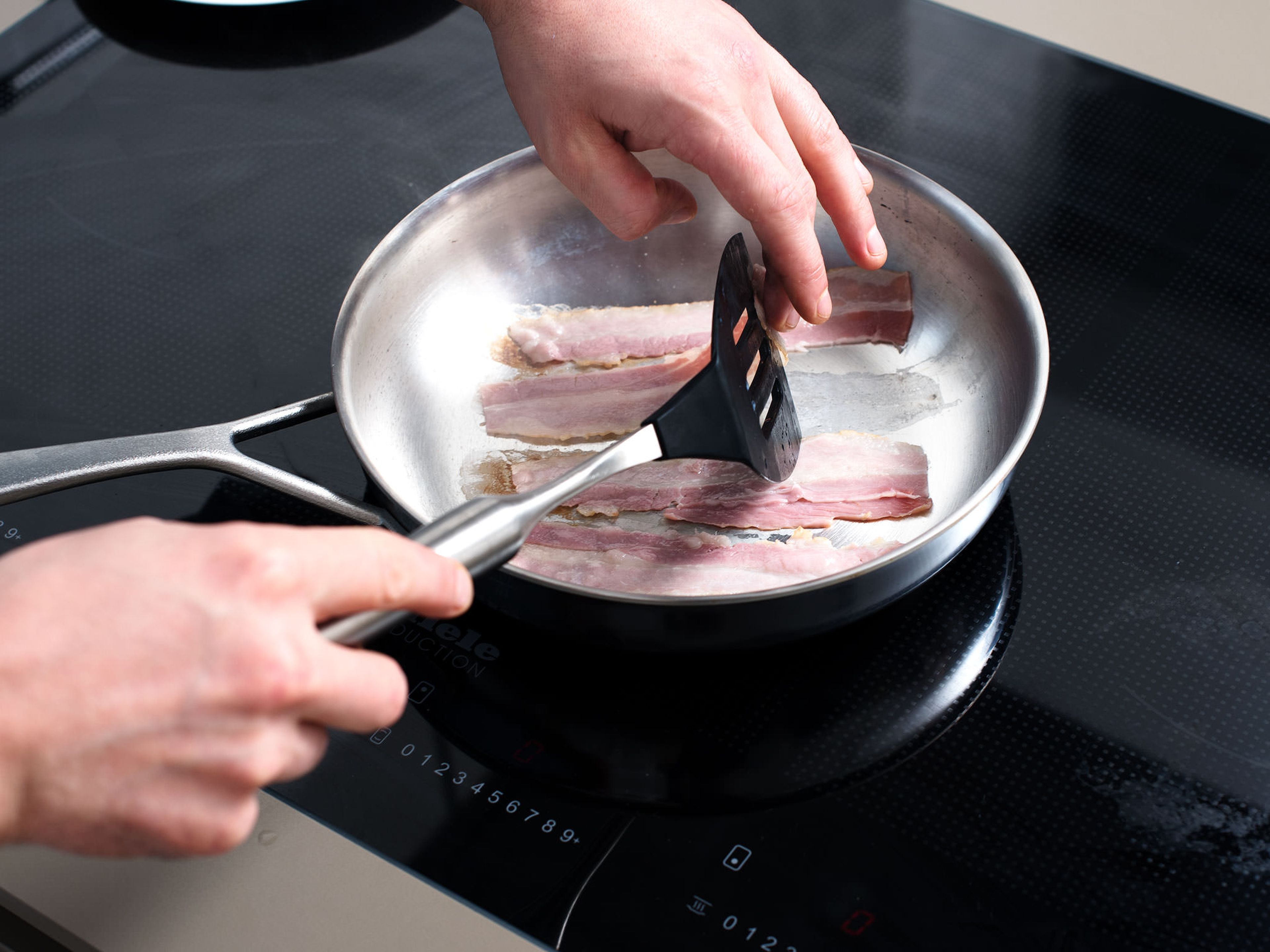Baconscheiben in einer großen Pfanne bei mittlerer bis hoher Hitze knusprig anbraten. Aus der Pfanne nehmen und abkühlen lassen.