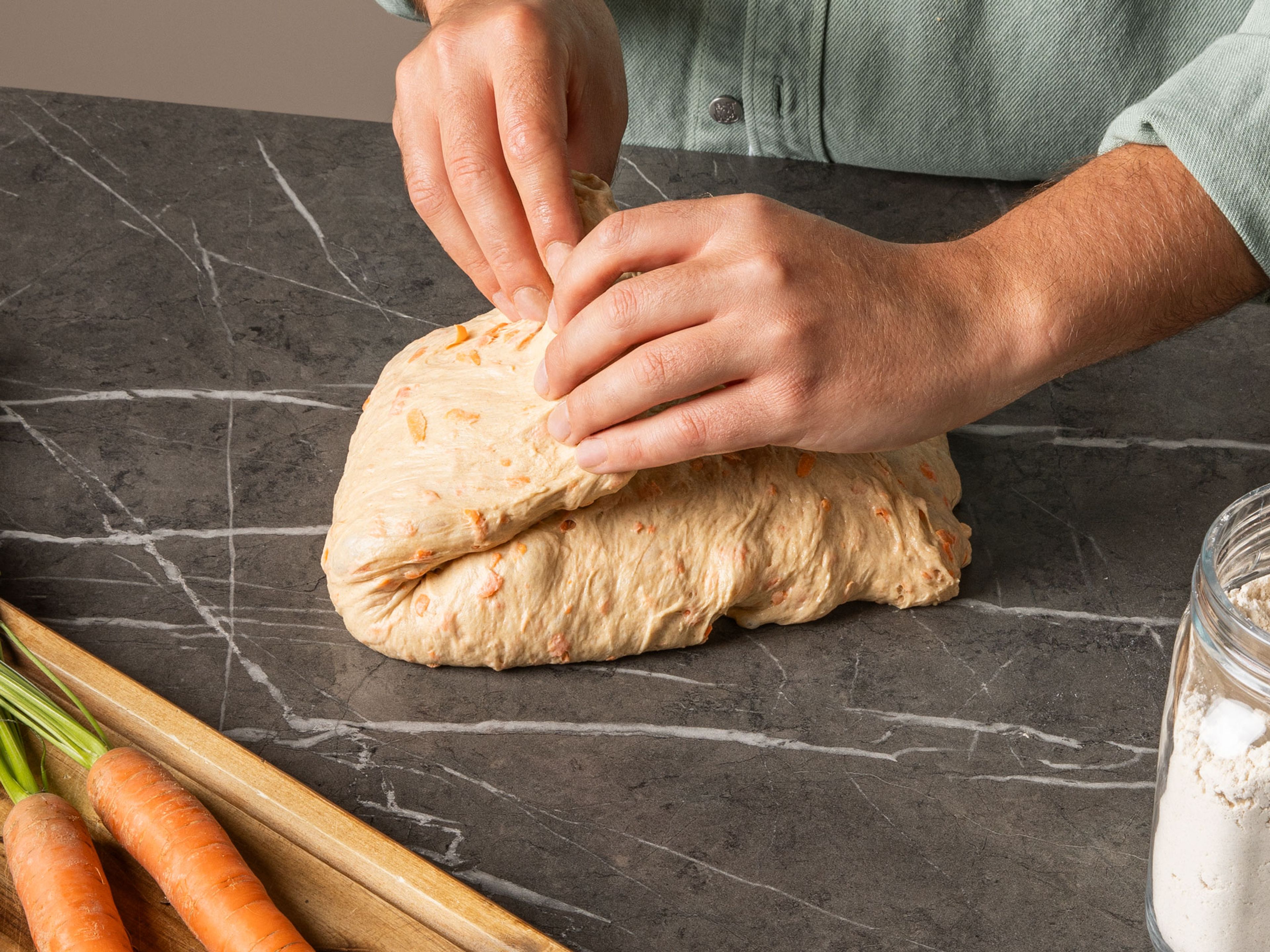 Once the dough has finished rising, slightly wet the counter and transfer dough to the surface. Using wet hands, slightly flatten the dough. Grab it from the end closest to you, pull it towards you and fold it into the middle. Continue with all four sides. Flip the dough over so the seam-side is on the counter and begin building tension on the surface of the dough by pulling it towards you in a circular motion using the outer sides of your palm. Do this a few times until the dough has a tight surface, wet your hands whenever necessary. Dust a proofing basket with lots of rice flour. Move it around to make sure all of the crevasses and sides are floured. Flour the top of the dough with rice flour and transfer seam-side up into the basket. Flour the exposed side of the bread as well. Cover the bread with a damp kitchen towel and allow to proof for another 1-1.5 hrs. or until it has doubled in size.