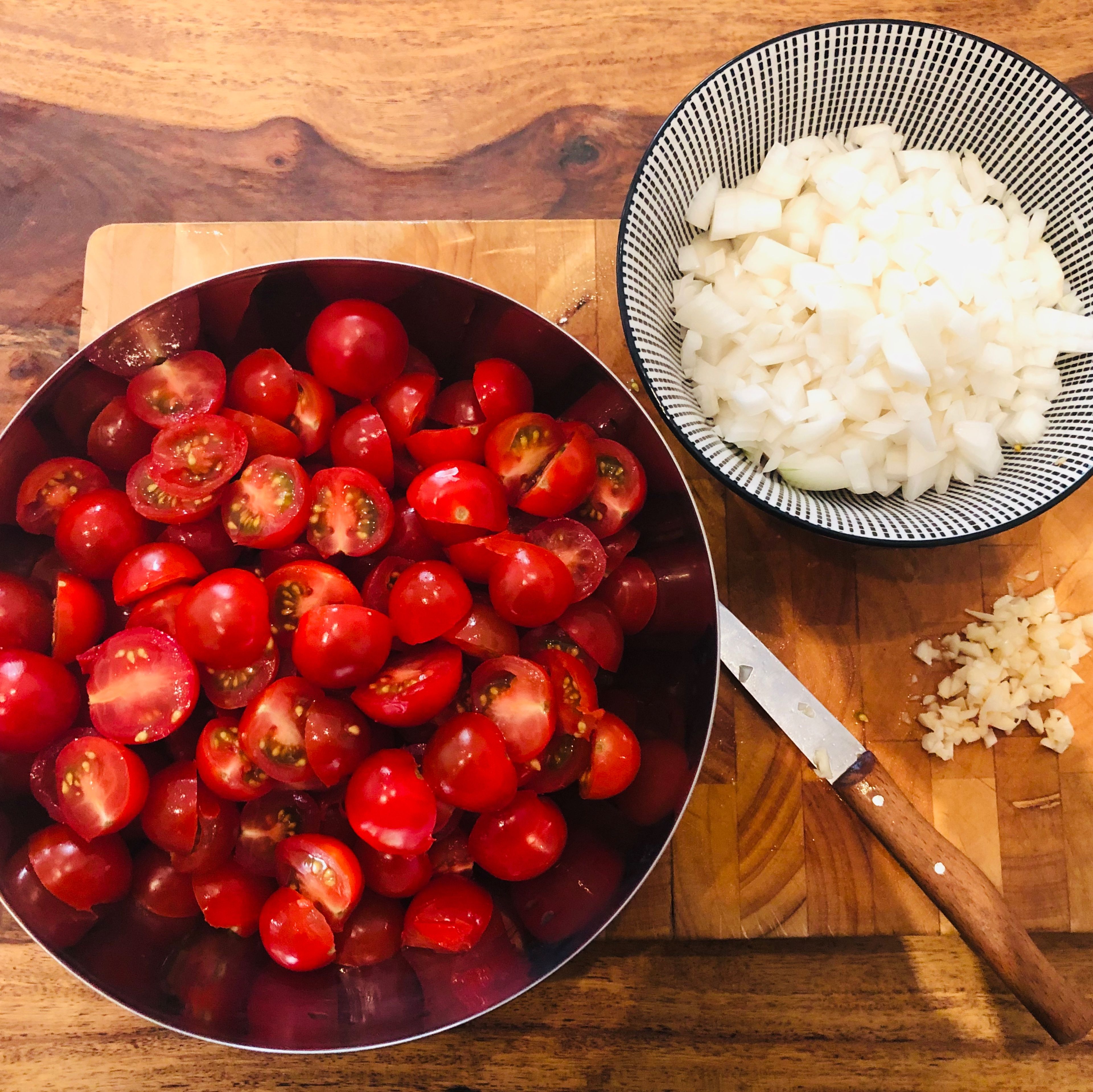 Jipih, es ist Zeit für hausgemachten Tomatenketchup! 🍅 Zuerst bereiten wir alles vor und schneiden die Tomaten, die Zwiebeln und den Knoblauch. Zwiebeln und Knoblauch dürfen fein geschnitten werden, die Tomaten können ruhig in etwas größere Stückchen geschnitten werden.