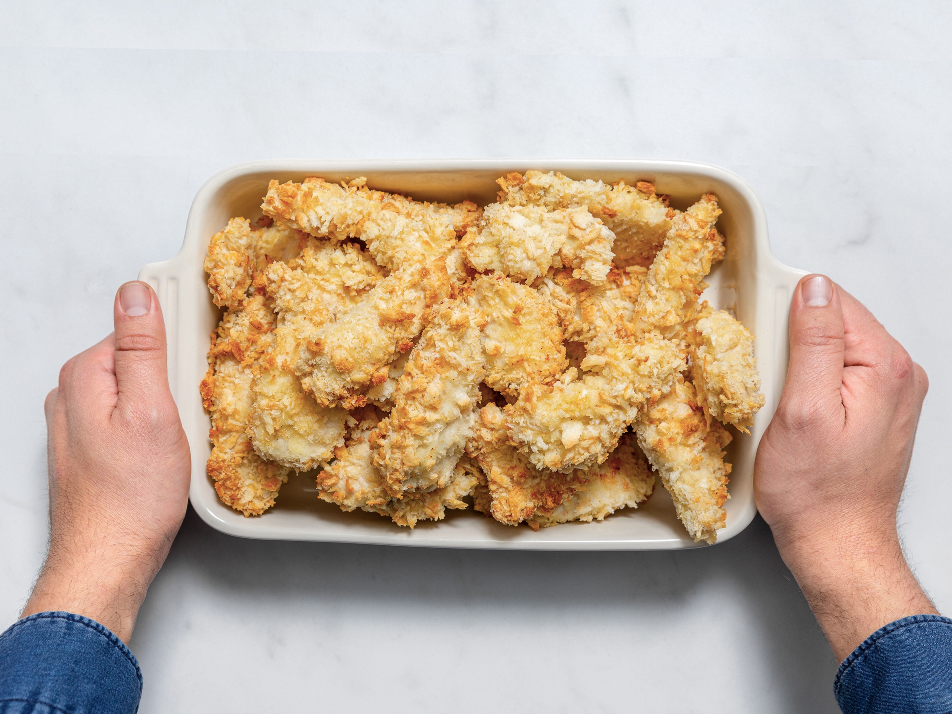 Bake at 200°C/400°F until golden brown and cooked through, approx. 15 min. Serve chicken strips immediately with various dips of your choice. Enjoy!