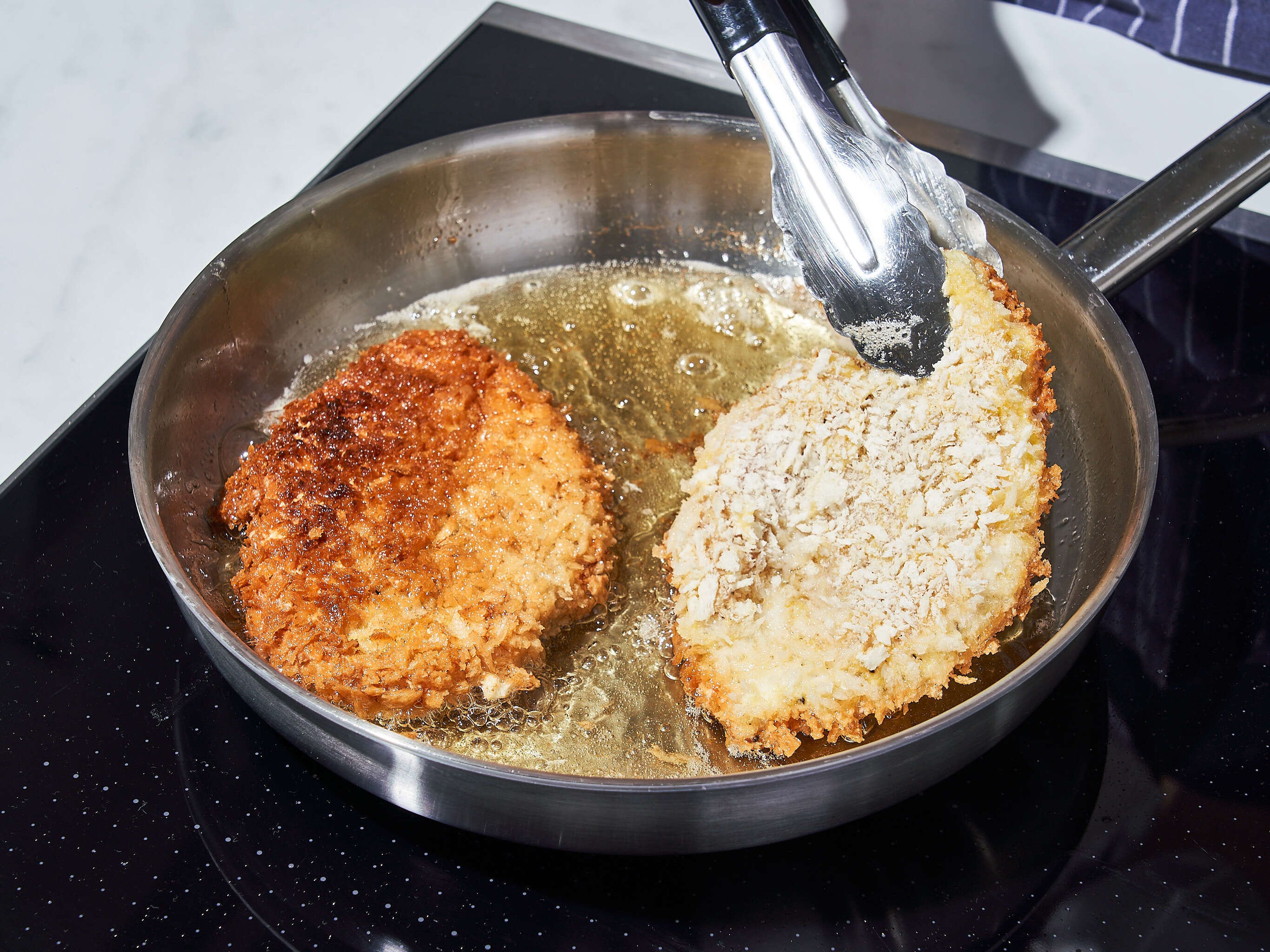 Add vegetable oil to a frying pan, set over medium heat. Whisk eggs in a rimmed plate or baking sheet and add remaining flour and panko breadcrumbs to two additional rimmed plates or baking sheets. Dredge the chicken breasts first in flour, then egg, and finally into the breadcrumbs. Shallow fry chicken breasts on each side for approx. 4 min., until golden brown and crispy. Serve with curry, cooked rice, and garnish with scallion, if desired. Enjoy!