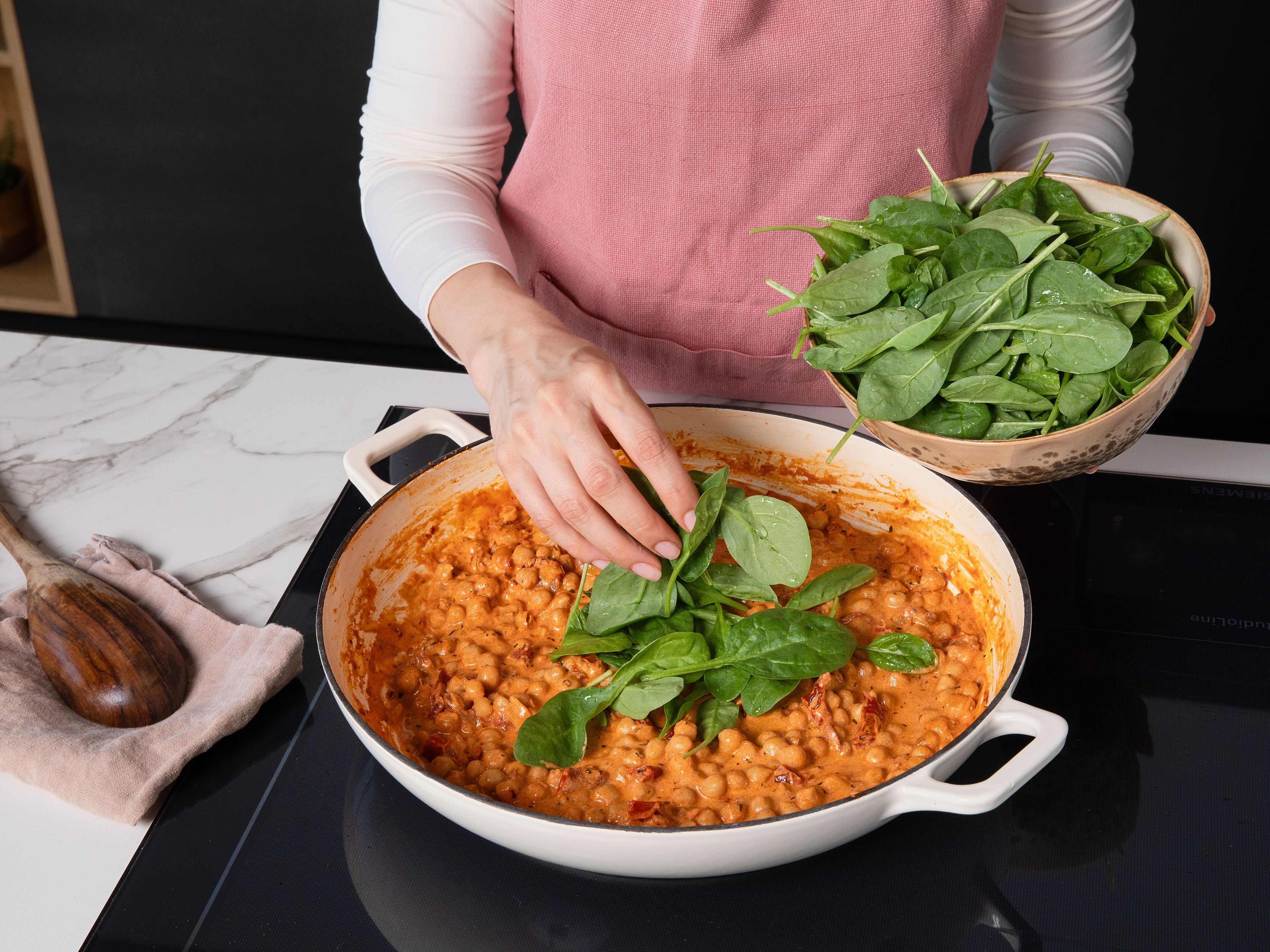 Babyspinat unter die Soße heben und ca. 1–2 Min. zusammenfallen lassen. Zum Servieren mit extra Parmesan und nach Belieben mit mehr Chiliflocken garnieren.