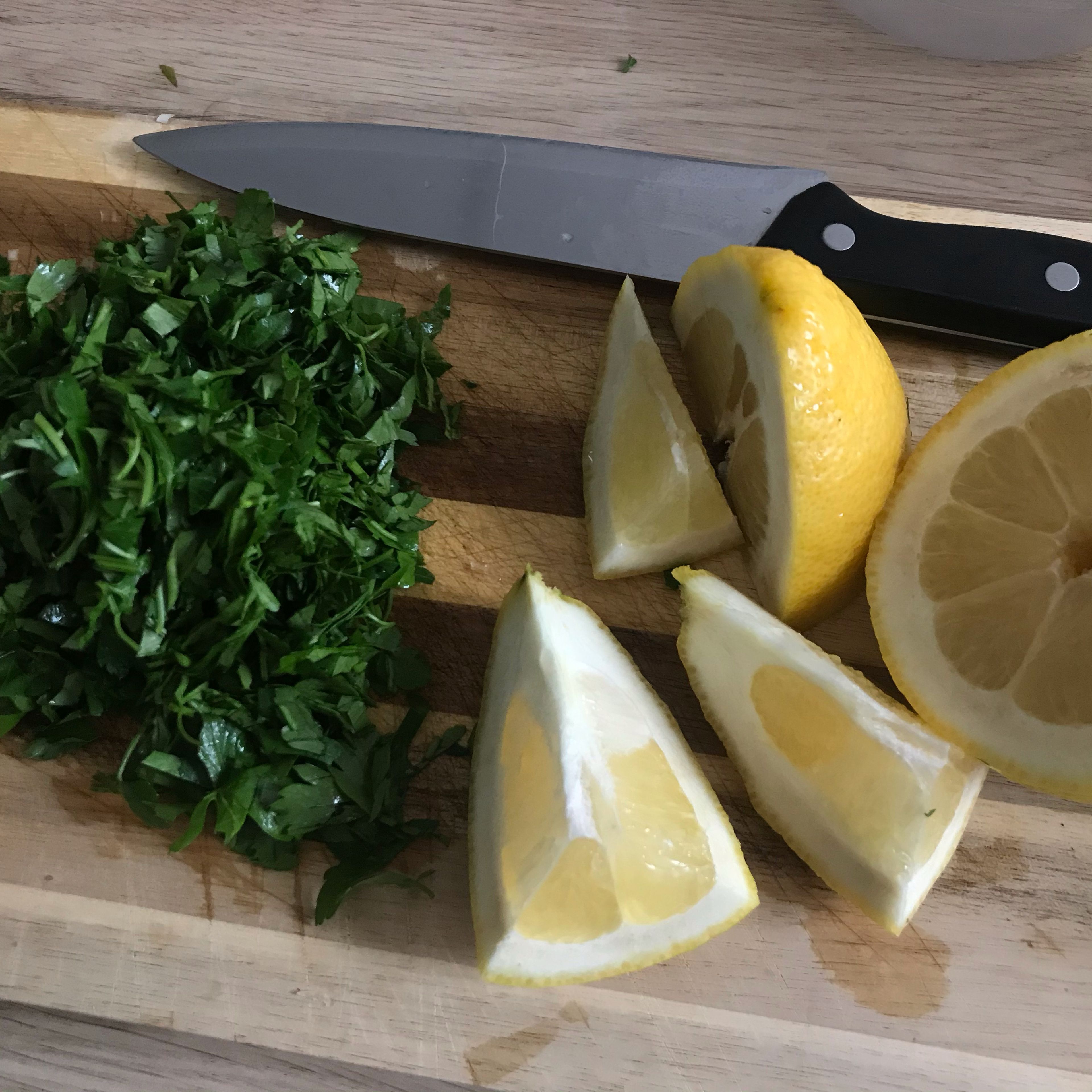 Währenddessen Salat und Zitronen waschen. Zitronen vierteln. Den Salat in handgroße Stücke schneiden und auf einem Teller verteilen.