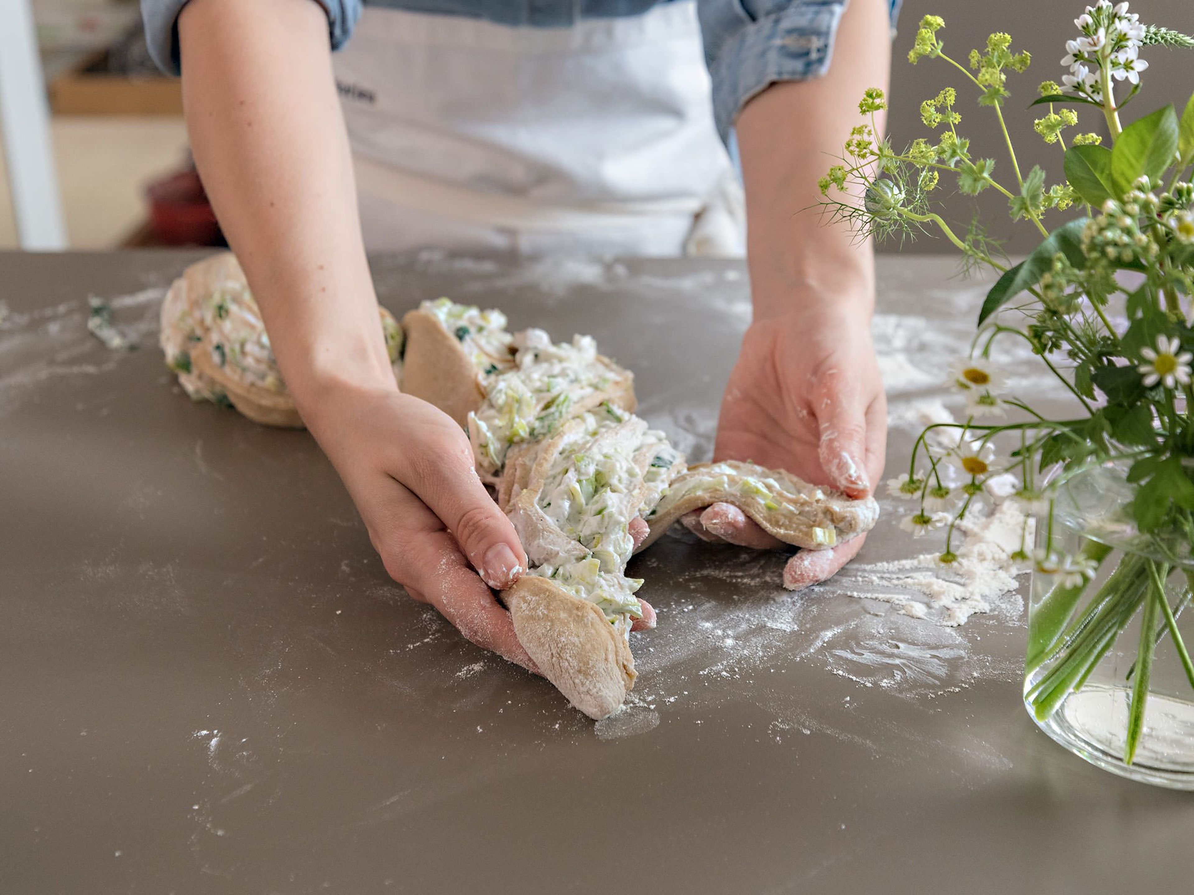 Cut half of the log in half lengthwise, and weave into a braid. Repeat with the other half of the log. Transfer dough to the loaf pan cut side-up and brush with olive oil.
