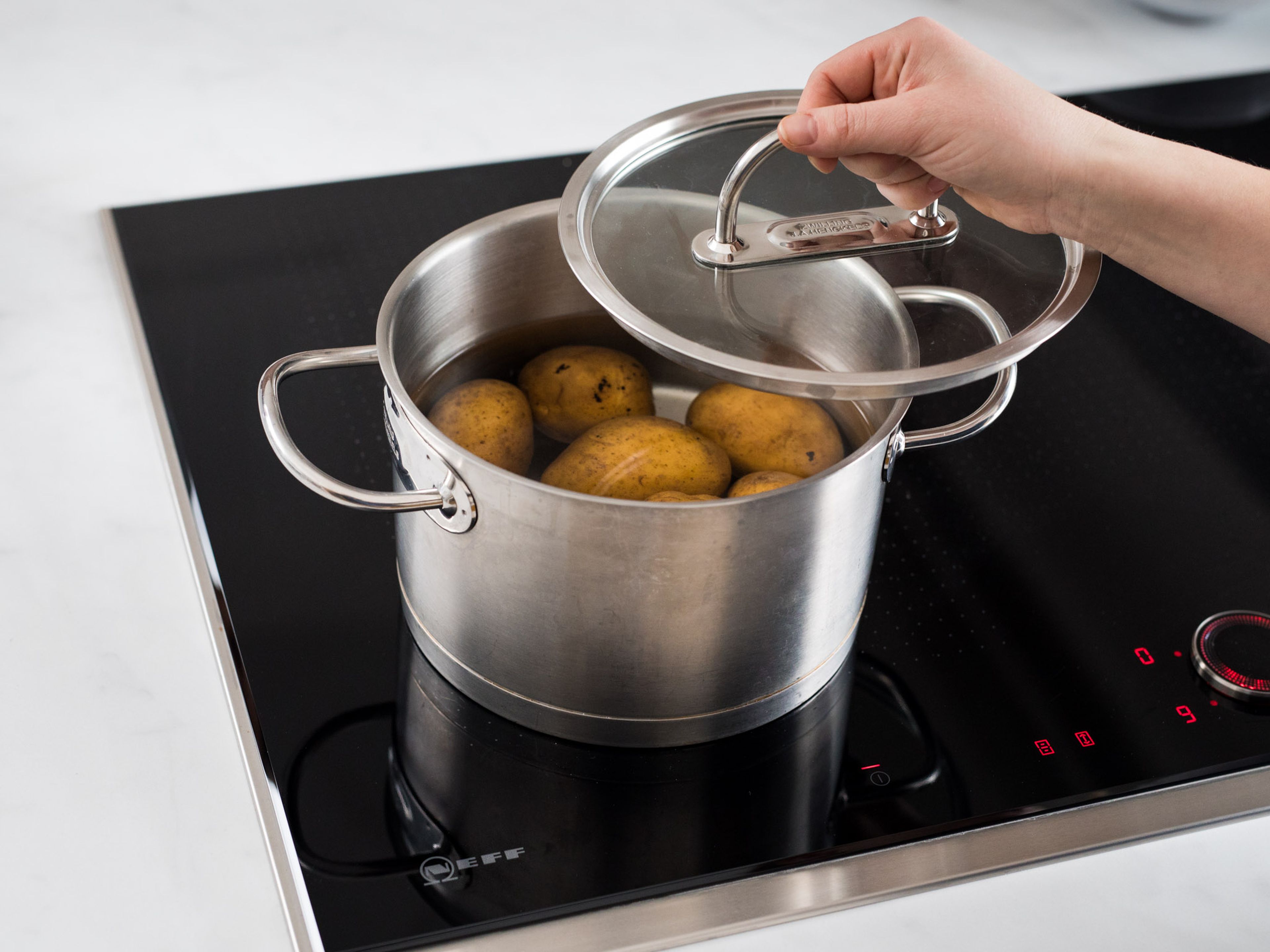 Kartoffeln in einen Topf geben, mit Wasser bedecken und salzen. Ca. 20 Min. kochen, oder bis sie weich. aber noch bissfest sind. Anschließend unter kaltem Wasser abspülen, schälen und längs halbieren.