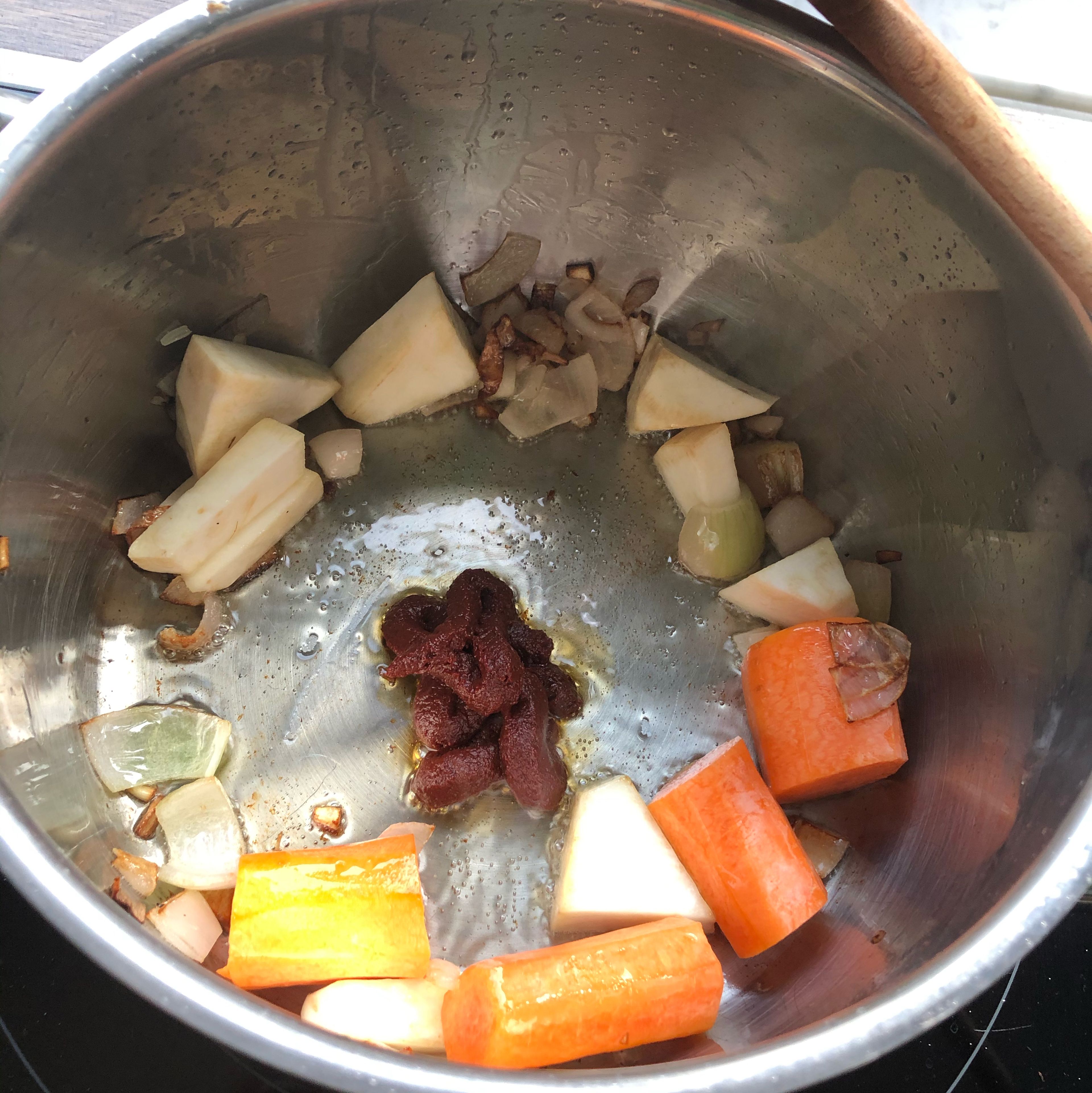 Rapsöl in einem Topf erhitzen und in der Zwischenzeit das Gemüse schneiden. Zuerst die Schalotten in den Topf und schön anrösten, anschließend die Karotte und den Sellerie hinzugeben. Alles kurz anrösten und dann das Tomatenmark in die Topfmitte setzen. Umrühren und zum Schluss den Lauch hinzugeben.