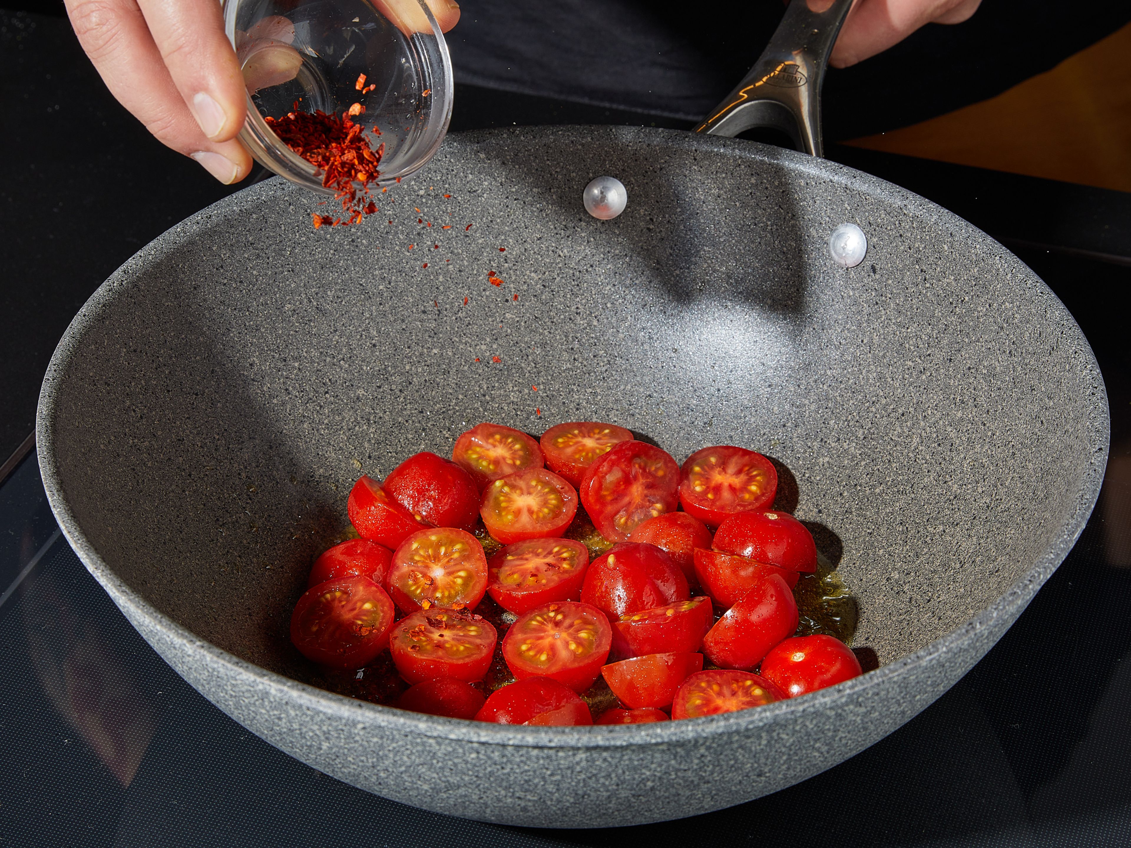 Bring a large pot of salted water to a boil. Meanwhile, in a dry pan, toast sunflower seeds over medium-high heat, tossing often, until slightly browned. Remove and set aside. Add olive oil to the used pan and heat. Add garlic and chili flakes, sauté briefly until fragrant, about 1 – 2 min. Now add cherry tomatoes and continue sauté for about 2 min.