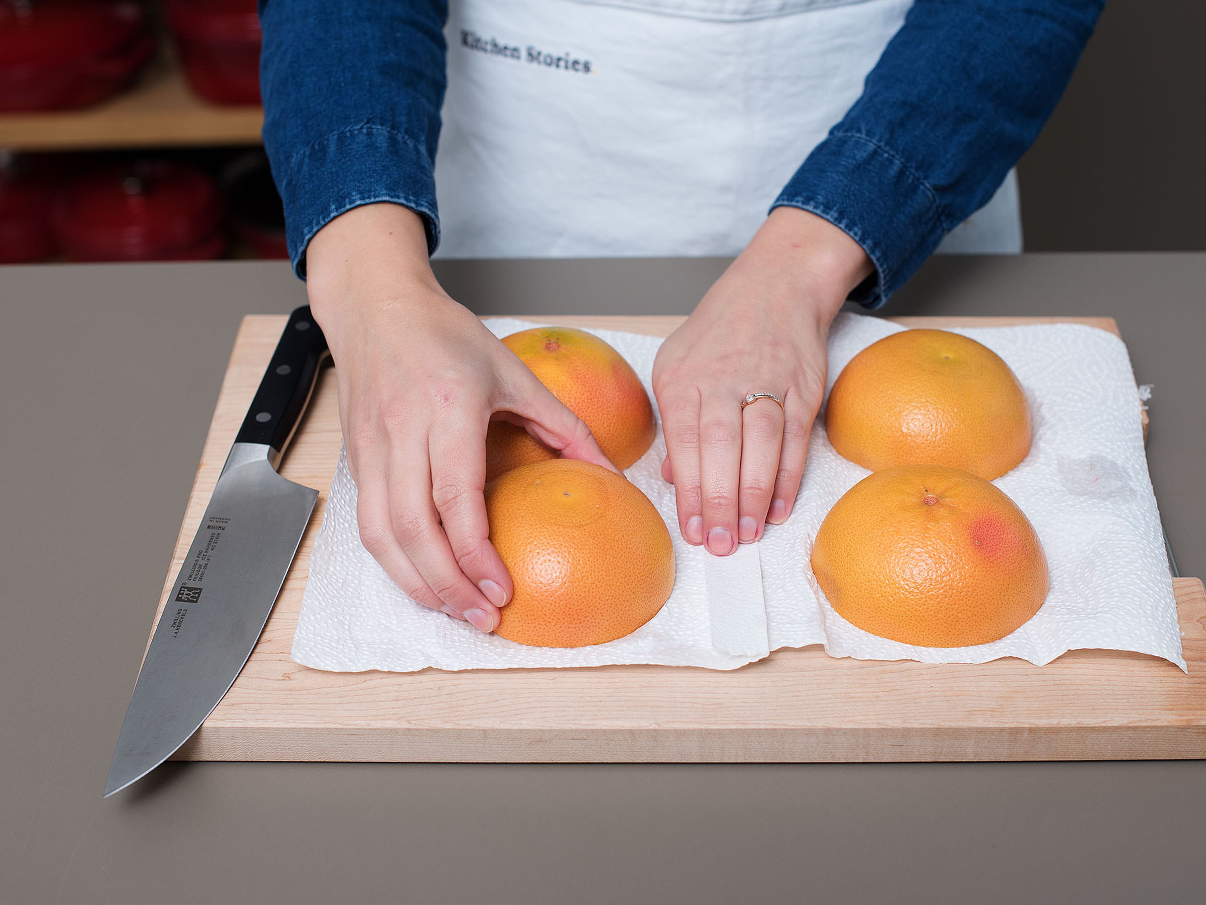 Die Grillfunktion des Backofens vorheizen. Grapefruits halbieren und falls nötig ca. 1 cm vom Boden abschneiden, damit die Grapefruits stabil stehen. Die einzelnen Grapefruitfilets einritzen, um sie zu lösen und später einfacher essen zu können. Die Grapefruithälften mit der Schnittseite nach unten ca. 5 Min. auf Küchenpapier legen um der Oberfläche Flüssigkeit zu entziehen.
