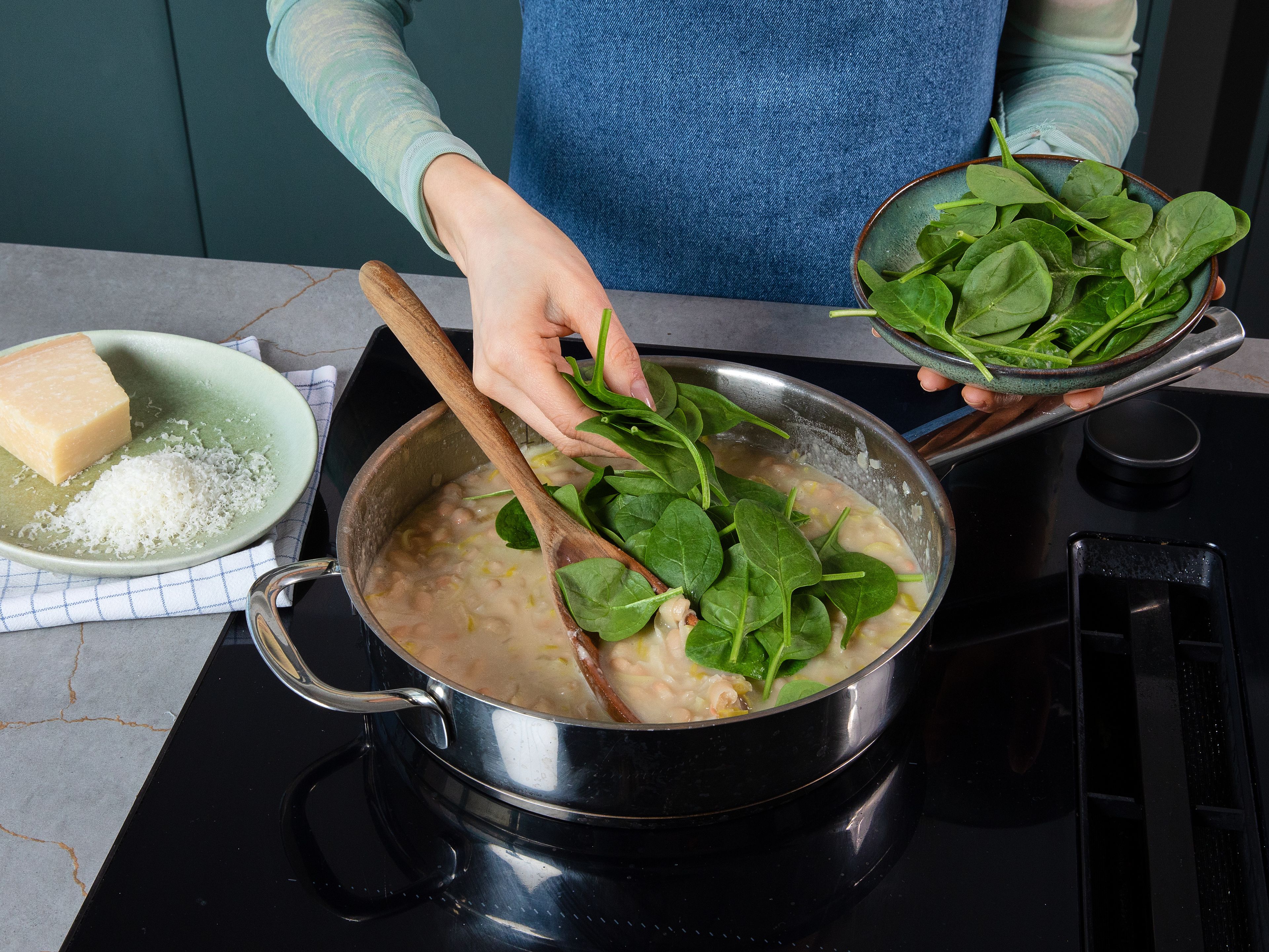 Restliche Butter und Parmesan unterrühren, bis alles cremig ist. Babyspinat unterheben und kurz zusammenfallen lassen. Mit Salz und Pfeffer abschmecken. Zum Servieren mit Pistazien, Petersilie, Zitronenzeste und etwas Olivenöl toppen und sofort servieren.
