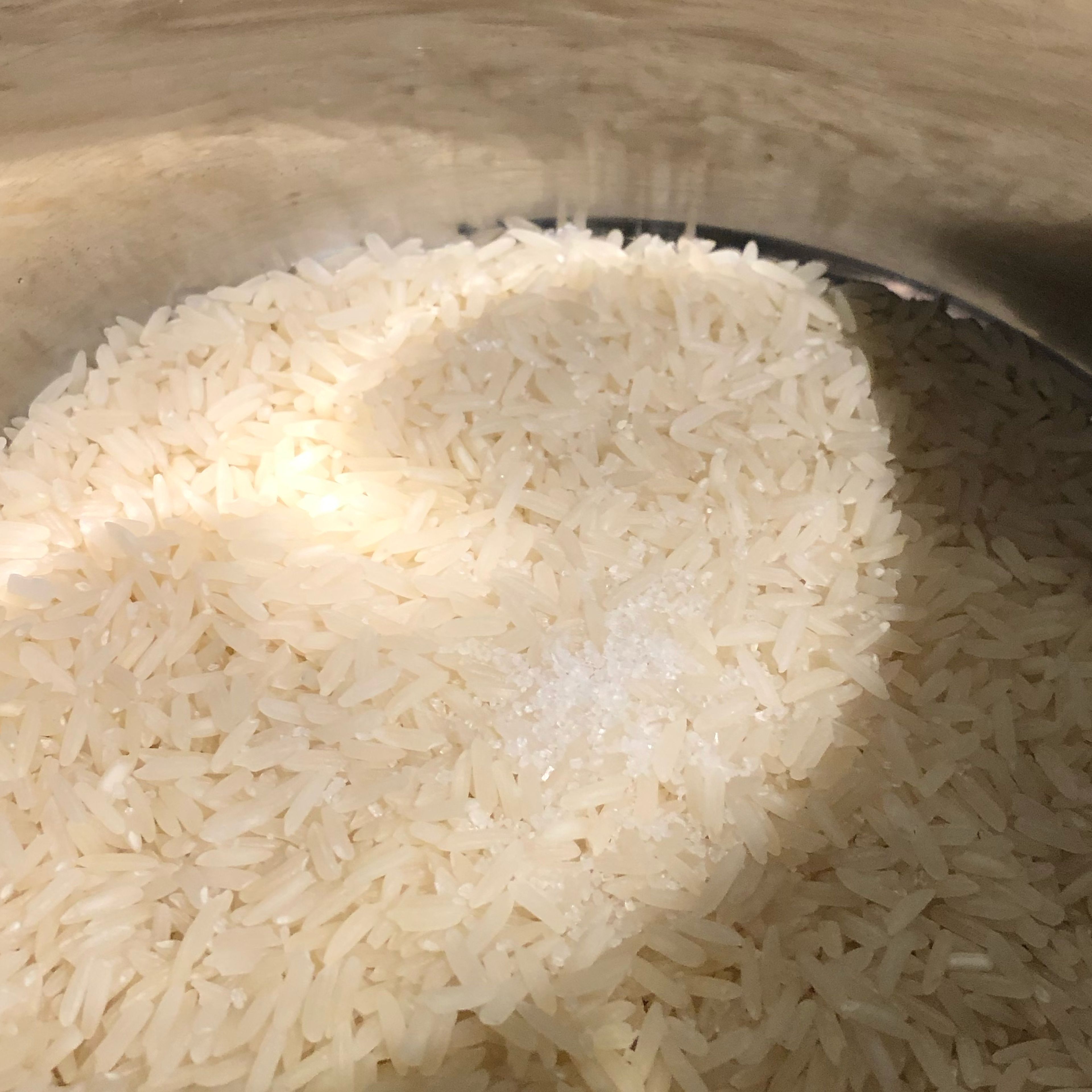 Reis in einen Topf geben und mit einer Prise Salz vermengen. Wasser hinzugeben und den Reis auf leichter Stufe garen bis das Wasser verdunstet ist. Immer mal wieder umrühren. 