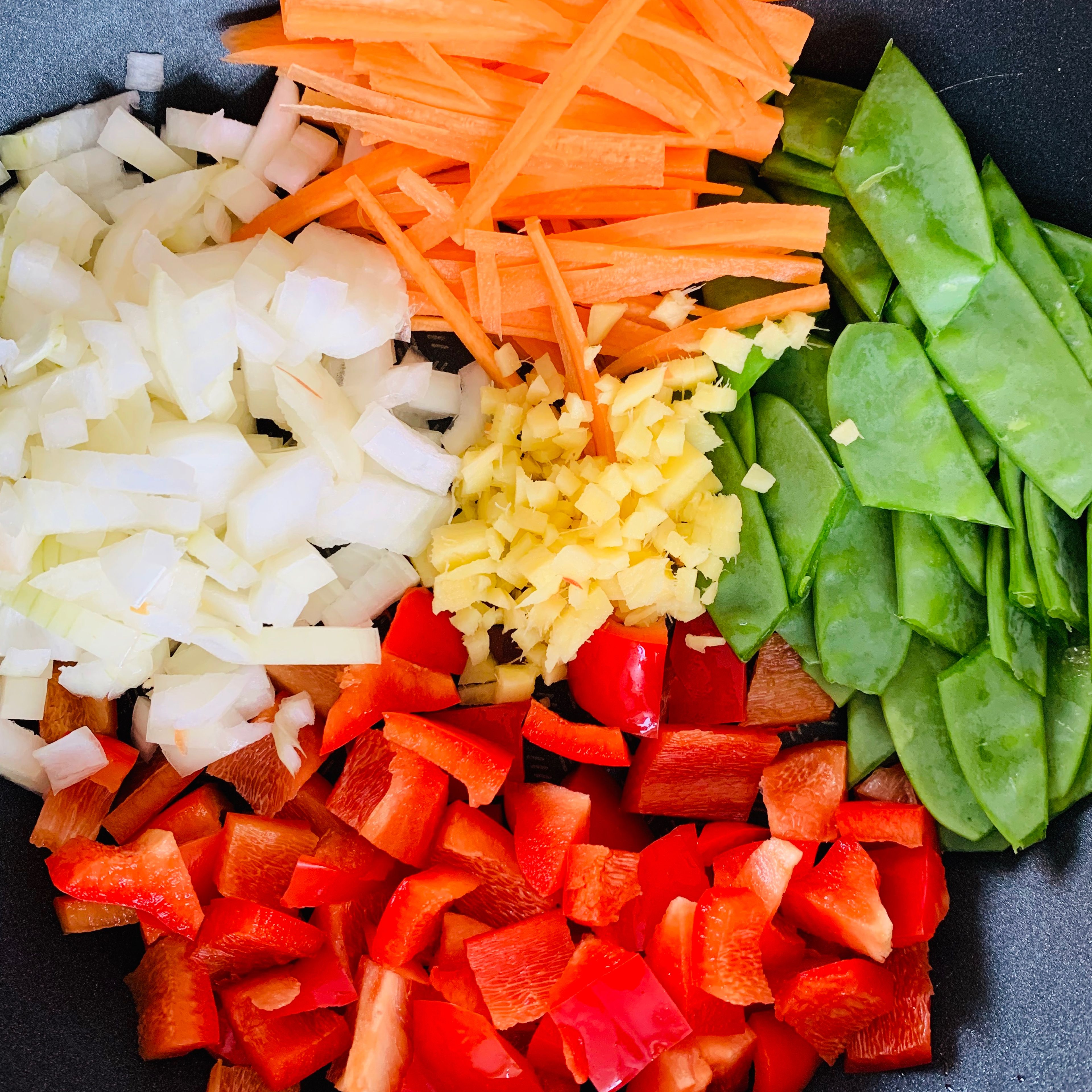 Cut the ginger, onion and pepper in dices. Half the mangetouts and cut the carrots in strips. Cut the chicken breast in chunks. 