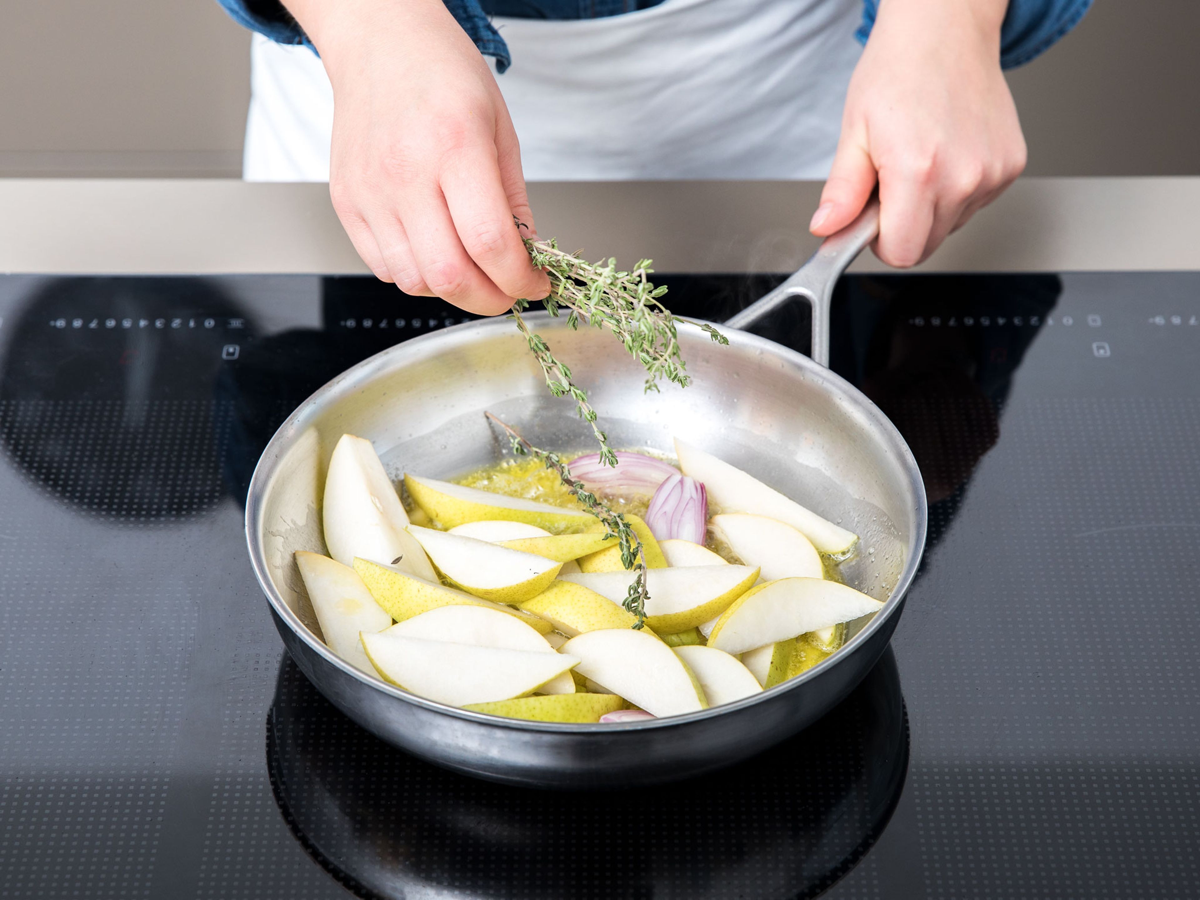 In a second pan, heat the butter and olive oil and add sliced pears, shallots, and thyme sprigs and sauté for approx. 5 min. Season with salt and pepper. Add the orange liqueur and let simmer for approx. 30 sec. more.