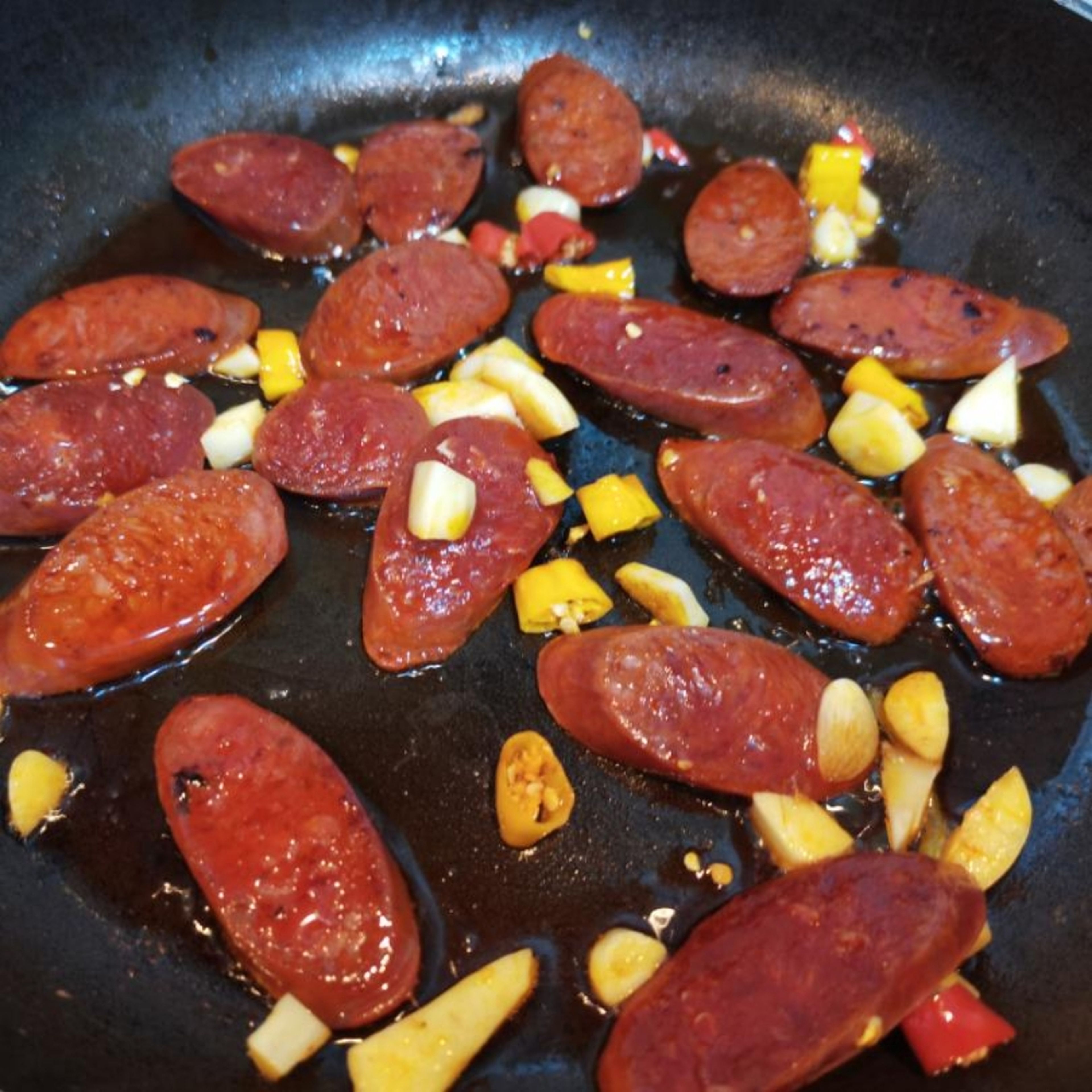 Put 1 tbsp oil in the frying pan, then fry garlic, chilli pepper until aromatic, then add chorizo in the pan for 3 min until the oil from chorizo comes out. Put cherry tomatoes in and cook for another 5 min.